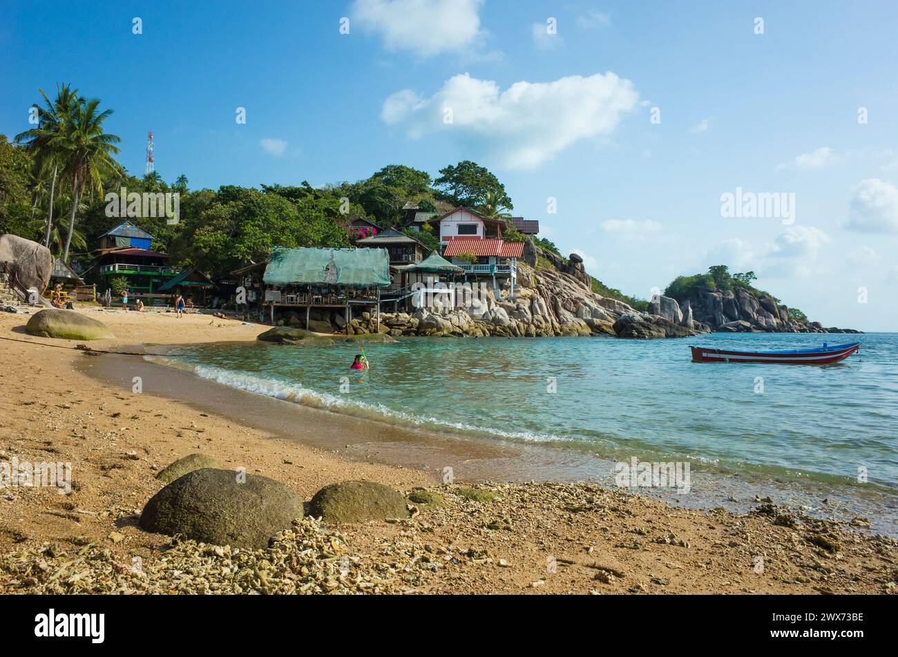 Coral sand on small Sai Nuan beach on tropical island Koh Tao, Popular destination for travel holidays in Thailand. Bungalows on cliff and boat on wat Stock Photo