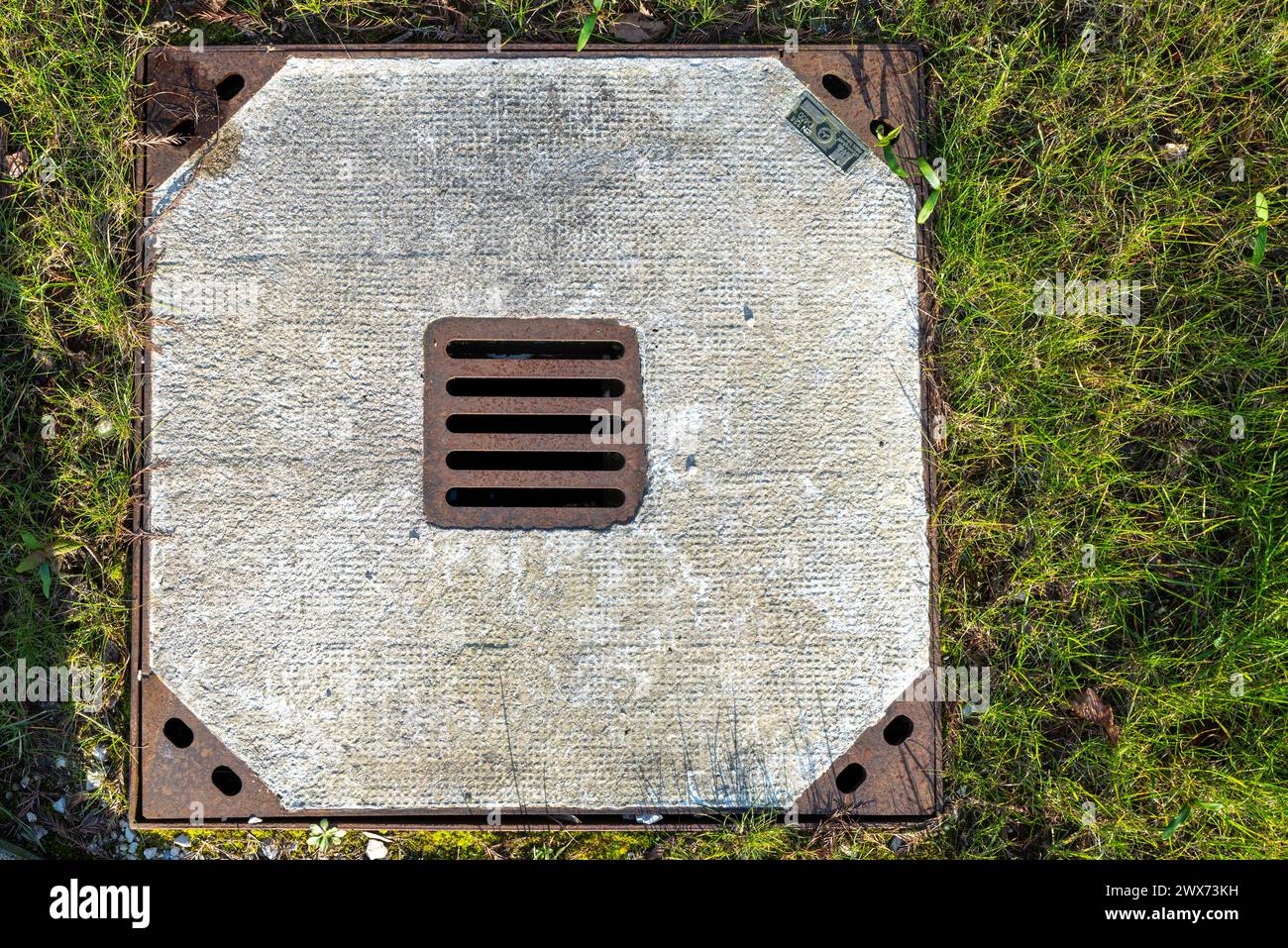 concrete manhole cover in meadow Stock Photo
