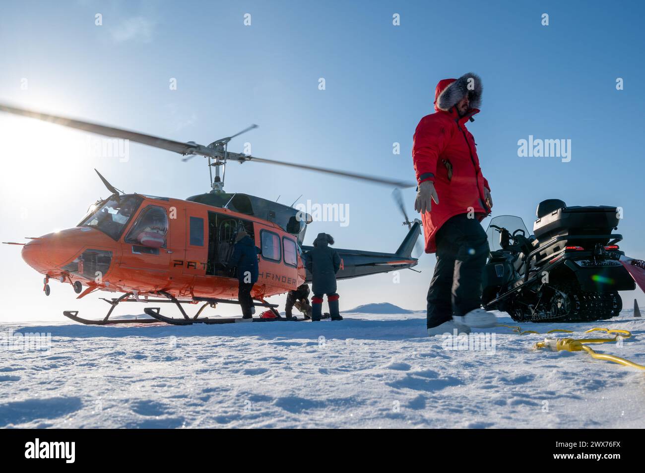 Personnel load equipment onto a Bell UH-1H helicopter during Operation Ice Camp at Ice Camp Whale, near Prudhoe Bay, Alaska, March 18, 2024 Stock Photo