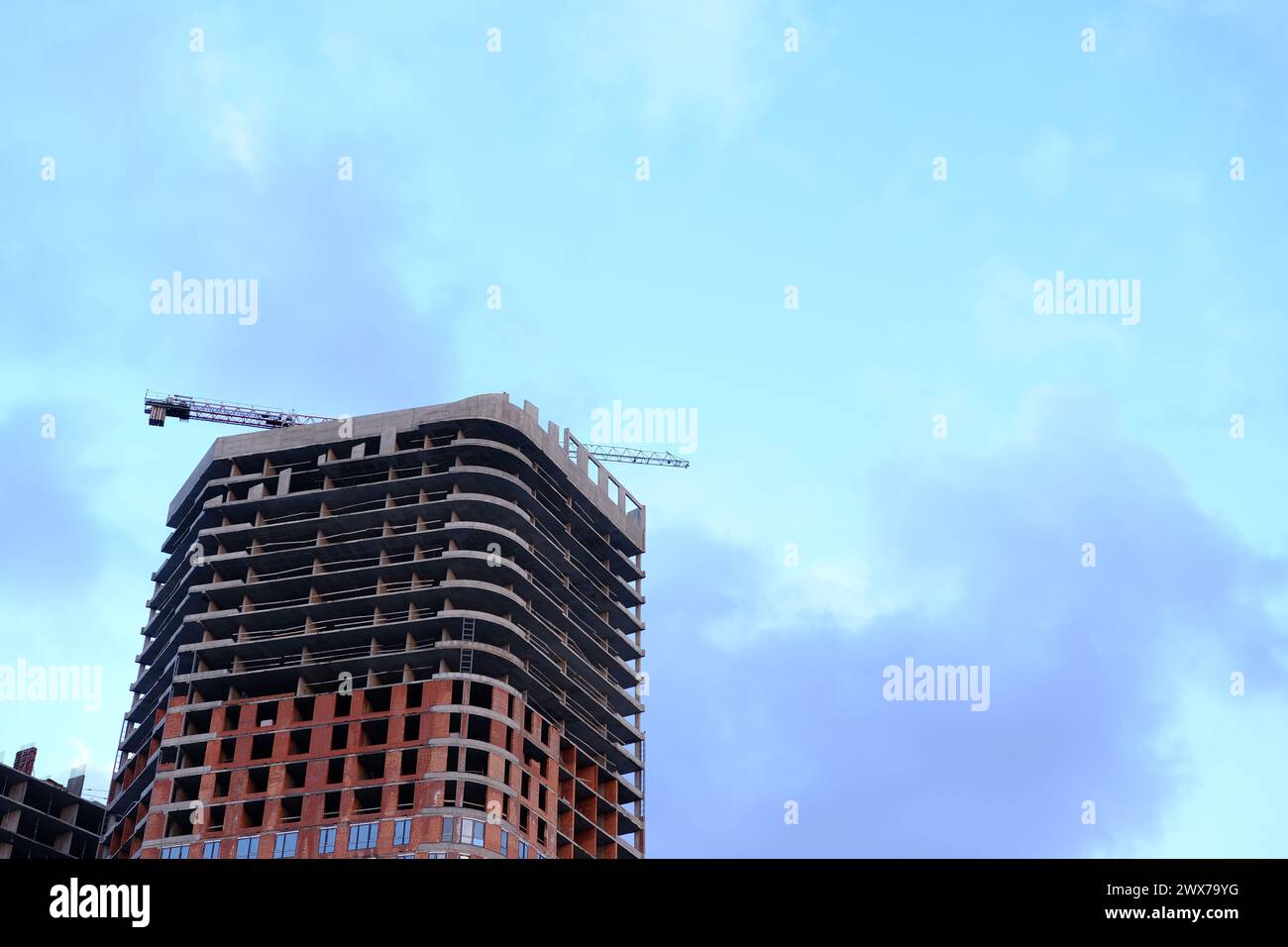 Low angle view of modern office building by construction site against sky in city Stock Photo