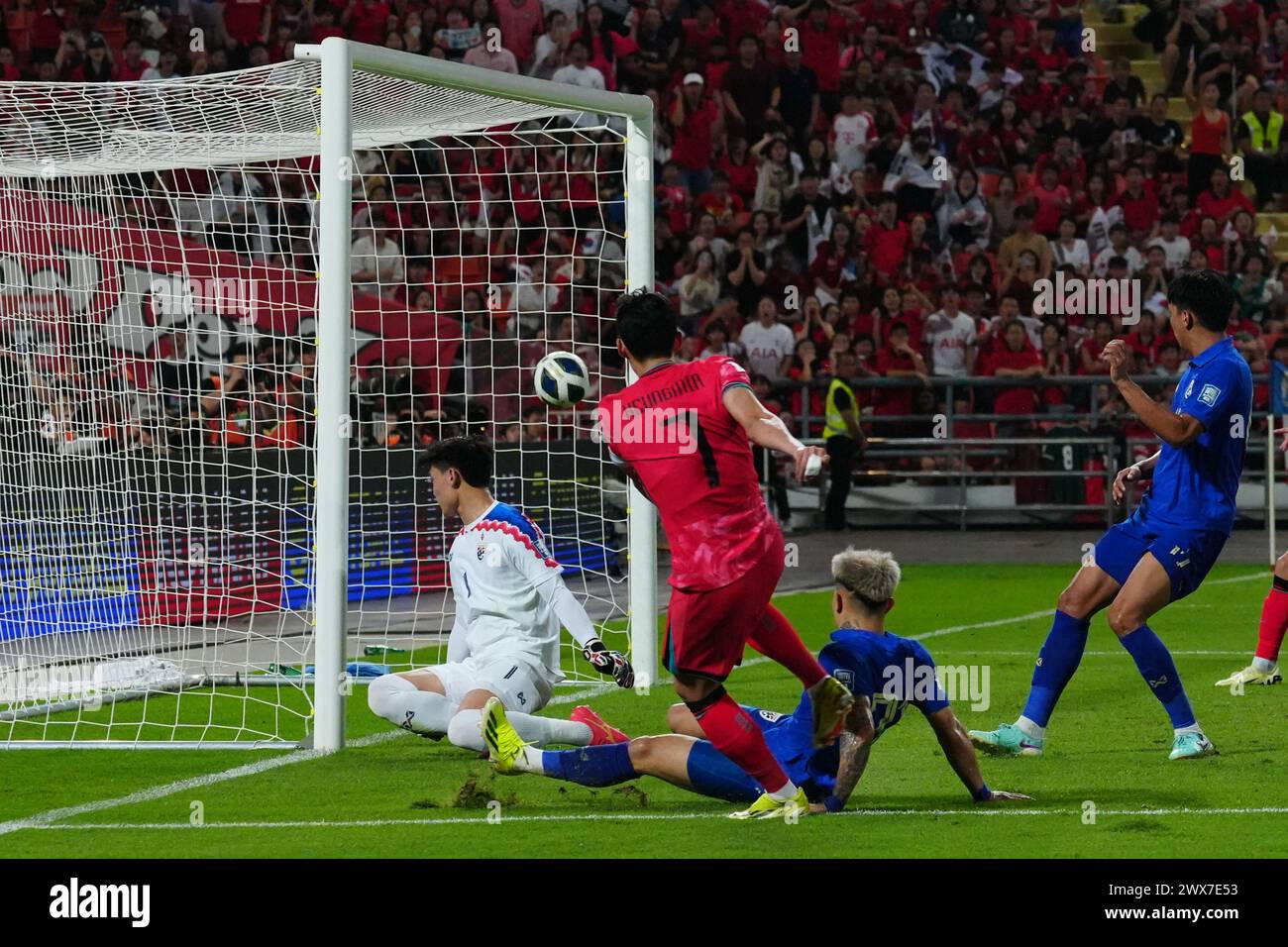 Bangkok, Bangkok, Thailand. 26th Mar, 2024. SON Heung min (red) touches the soccer ball past the goalkeeper of the Thai national team to take the lead, during the FIFA World Cup Qualifying (Group C) match Thailand 0 - 2 Korea Republic at Rajamangala Stadium on March 26th, 2024 in Bangkok, Thailand. (Credit Image: © Teera Noisakran/Pacific Press via ZUMA Press Wire) EDITORIAL USAGE ONLY! Not for Commercial USAGE! Stock Photo