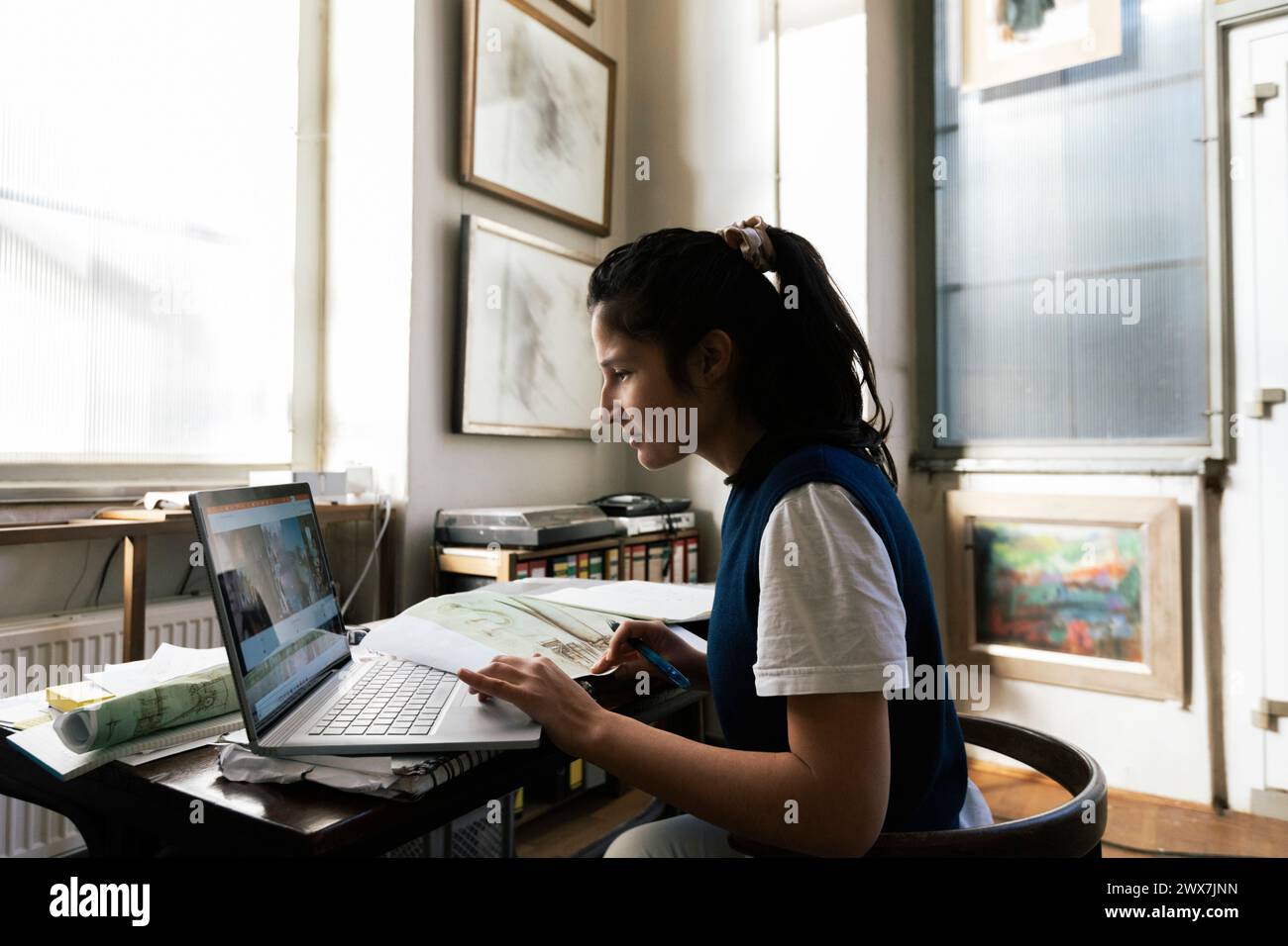 Businesswoman using laptop on table while working at home Stock Photo