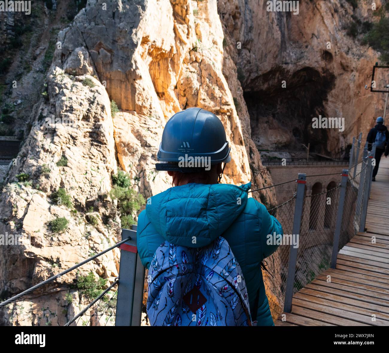 a mature female hiker, advances along hanging platforms in a ravine in southern andalucia Stock Photo