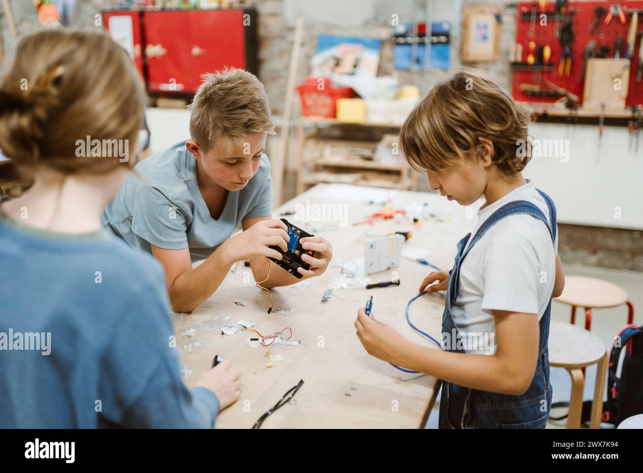 Male and female pupils working on robotics project on table in workshop Stock Photo