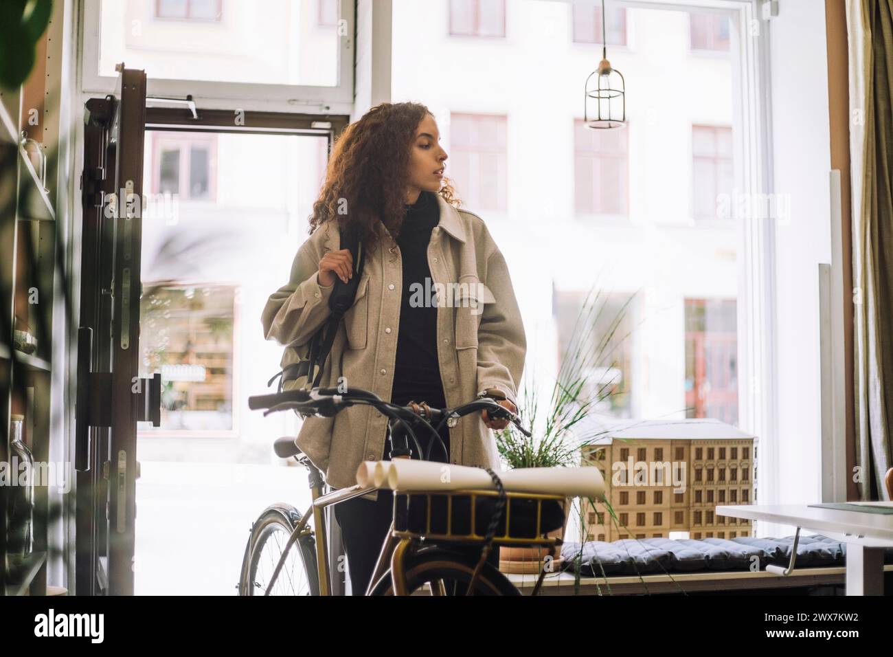 Female architect arriving at office with bicycle Stock Photo