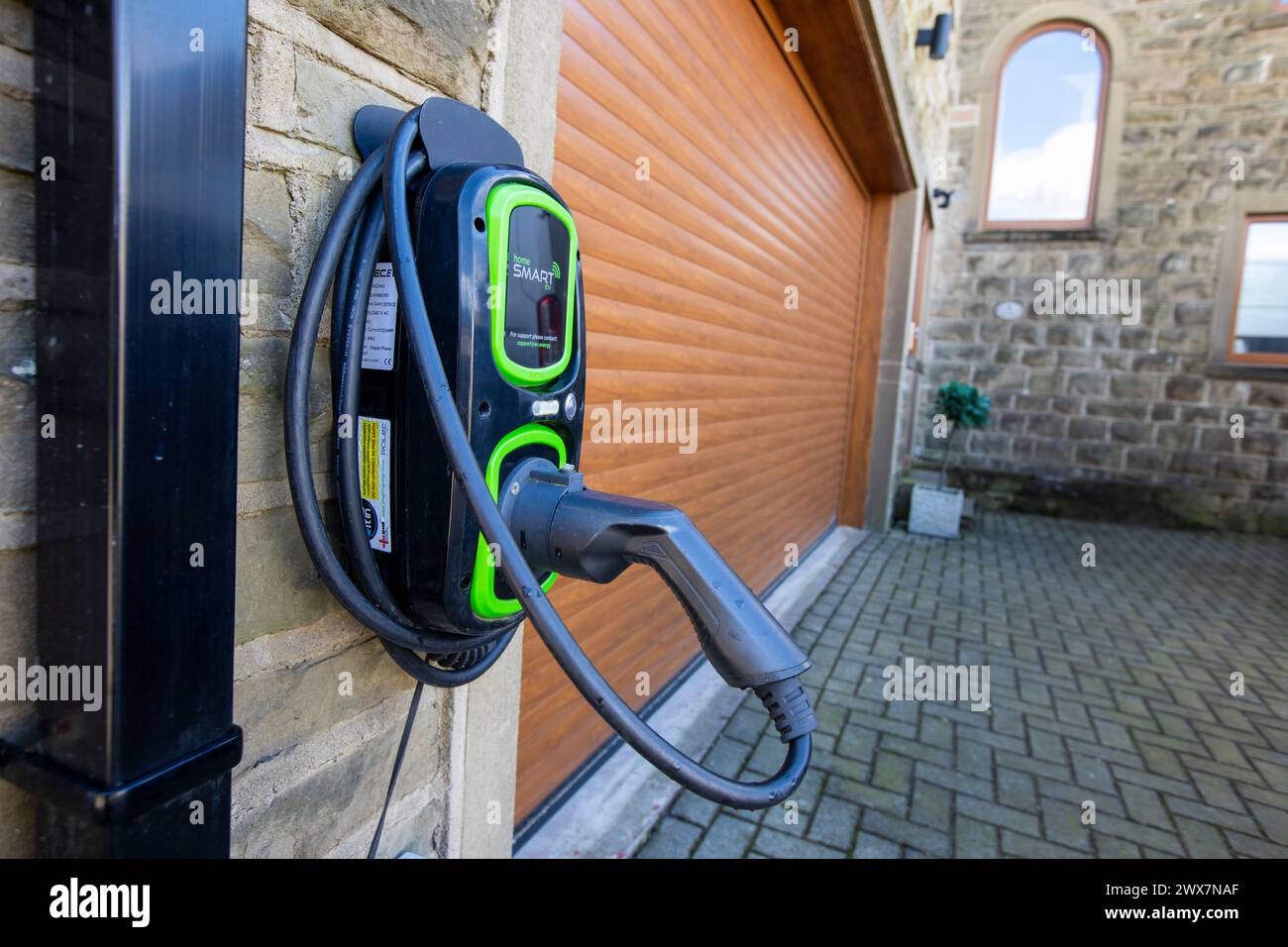 Electric car charging points with charging cable at West Yorkshire homes near Queensbury in the Pennines Stock Photo