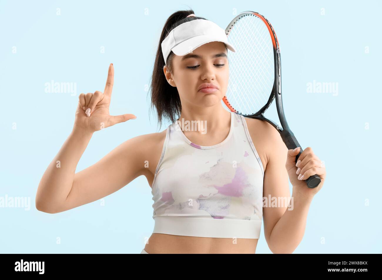 Lose Respect Throwing Racket Sporty young woman with racket showing loser gesture on blue background ...