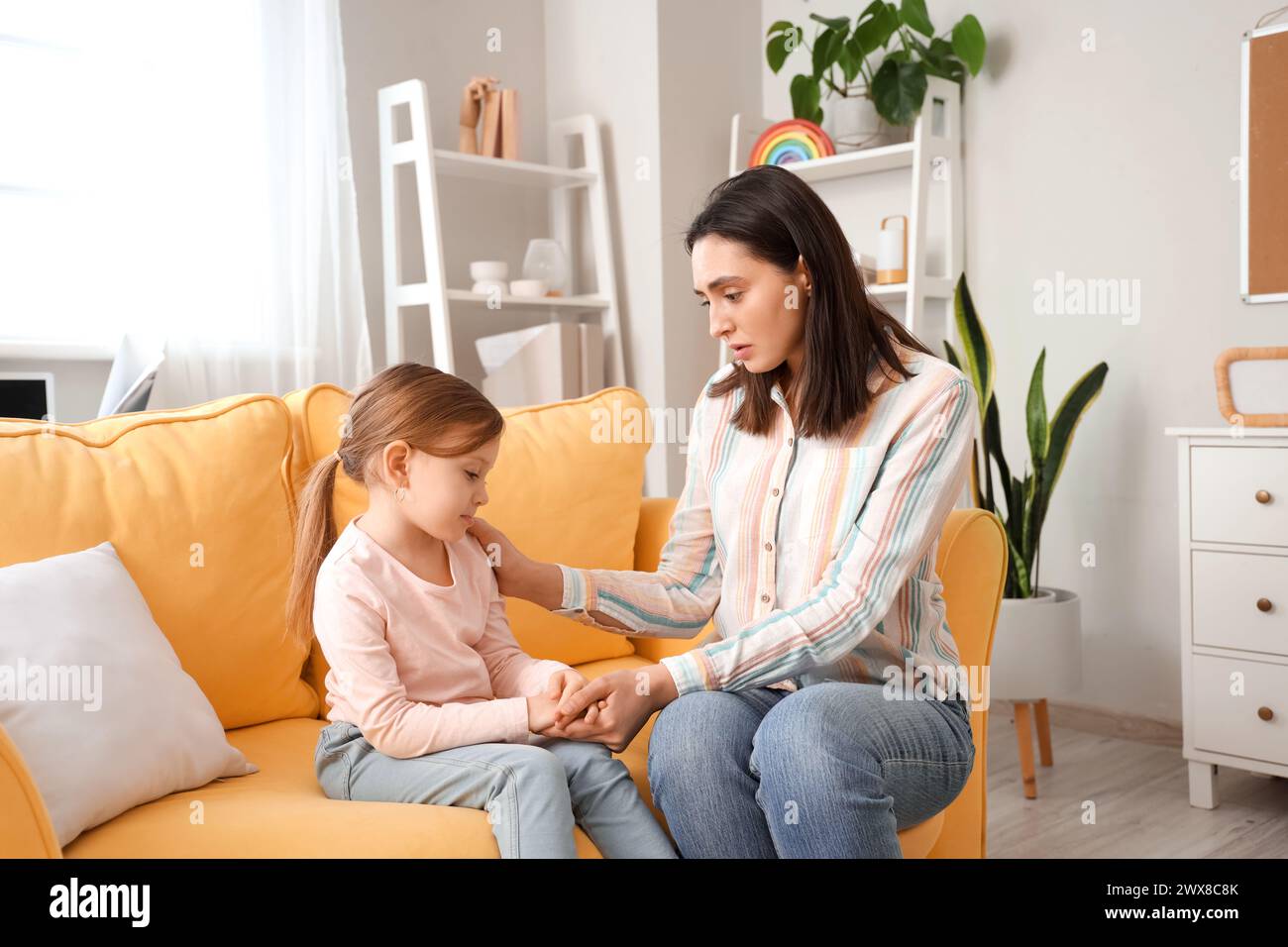 Upset little girl with psychologist holding hands in office Stock Photo ...