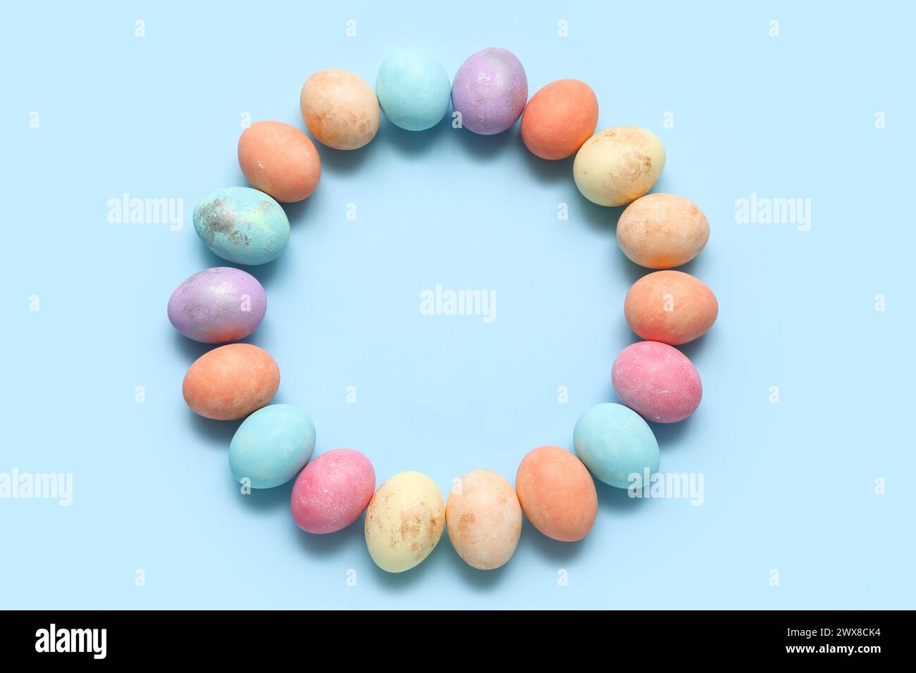 Frame made of painted Easter eggs on blue background Stock Photo