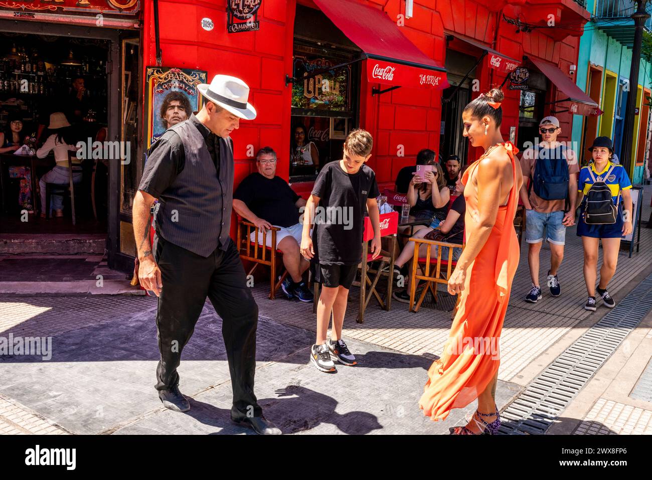 Two Tango Dancers Showing A Boy How To Dance The Tango Outside A Cafe In The Colourful La Boca District of Buenos Aires, Argentina. Stock Photo