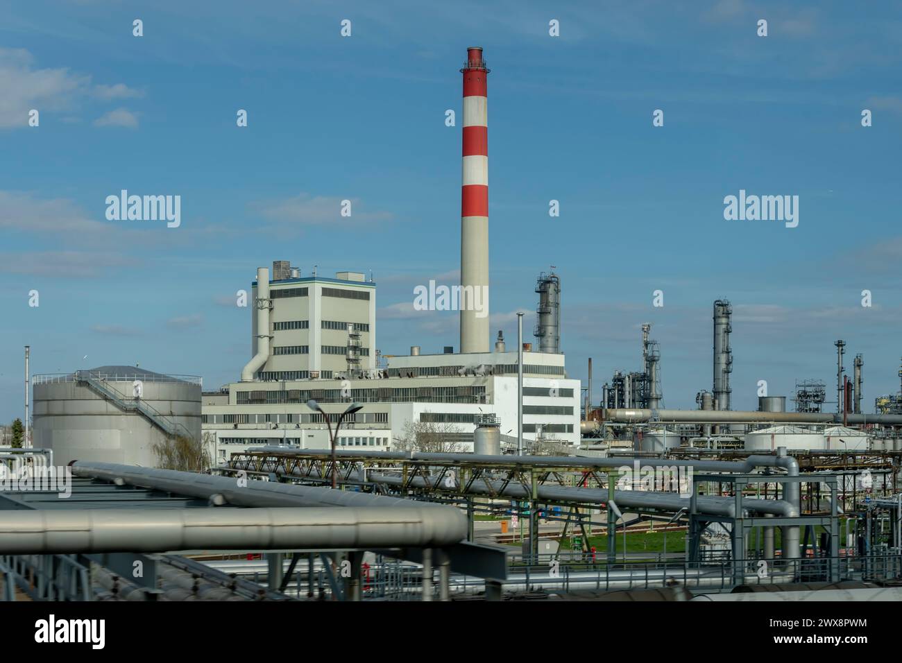 Oil refinery and petrochemical industrial plant against blue sky, oil and gas processing tanks, industrial area. Stock Photo