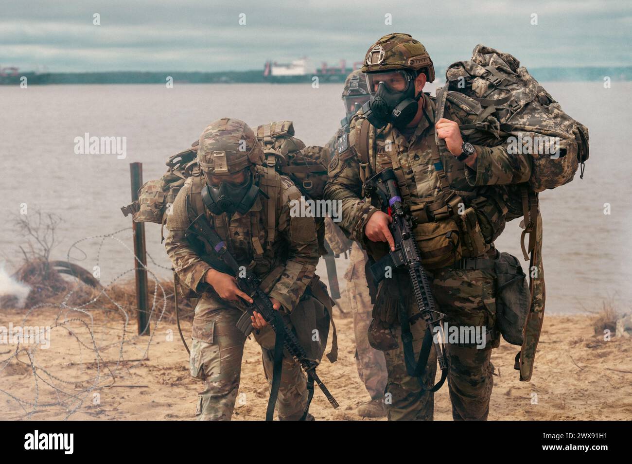 U.S. Army Sgt. Mireya Rosales-Peres and Staff Sgt. Roman Zaytsev, 44th Medical Brigade, ruck in a simulated Chemical, Biological, Radiological, and Nuclear (CBRN) environment at Joint Base Langley-Eustis, Virginia, March 5, 2024. The U.S. Army Best Squad Competition, a bi-annual event hosted by the 7th Transportation Brigade (Expeditionary) this year, allows squads to safely demonstrate their mission readiness and represent the XVIII Airborne Corps at higher levels of competition.(U.S. Air Force photo by Airman 1st Class Skylar Ellis) Stock Photo