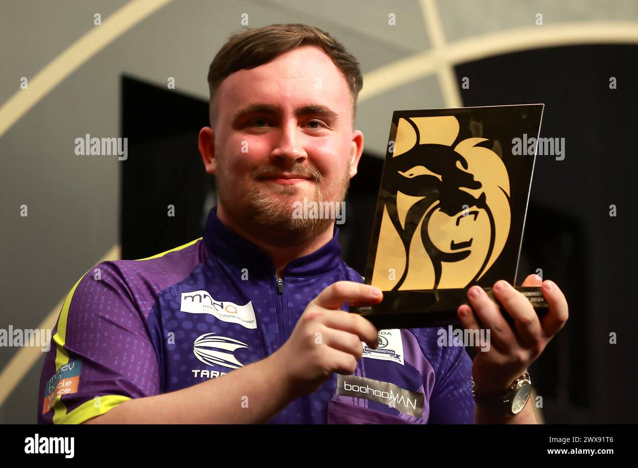 Luke Littler celebrates with the trophy after victory in the final ...