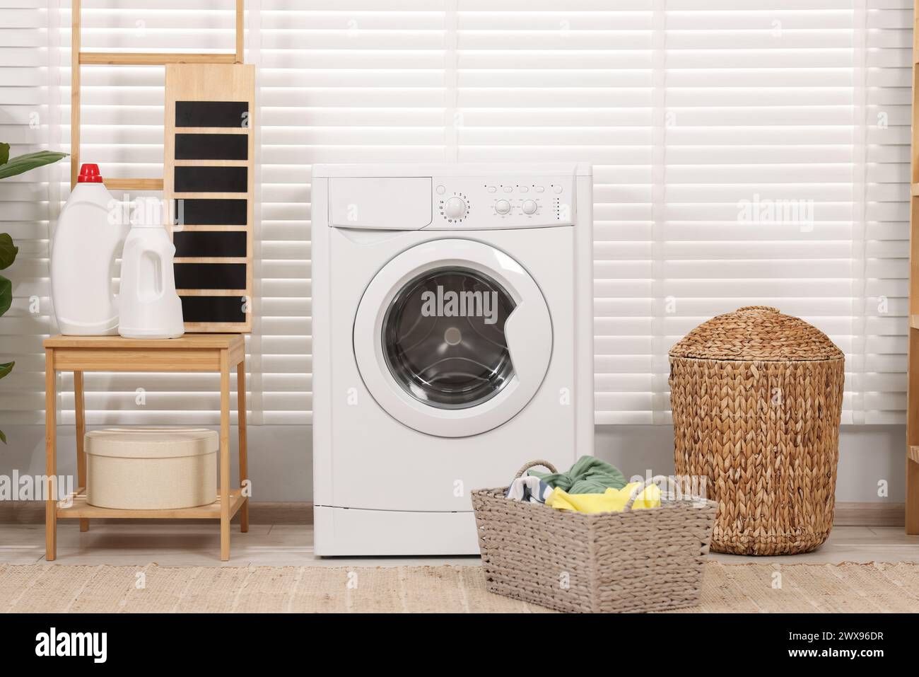 Laundry room interior with washing machine and baskets Stock Photo - Alamy