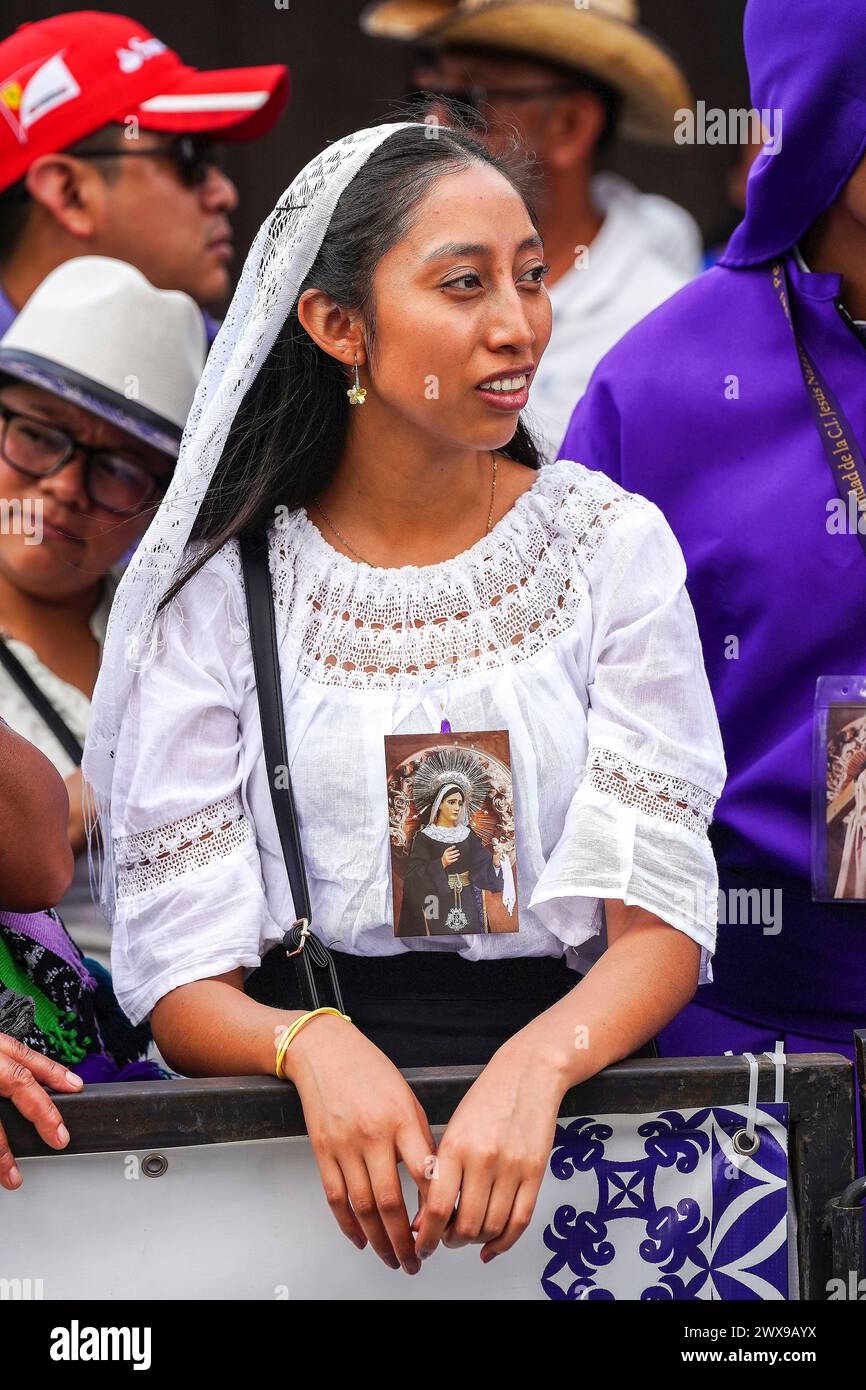 Antigua, Guatemala. 28th Mar, 2024. A Guatemalan woman dressed in mourning costume watches processional floats depart from the San Francisco El Grande church at Semana Santa, March 28, 2024 in Antigua, Guatemala. The opulent processions, detailed alfombras and centuries-old traditions attract more than 1 million people to the ancient capital city. Credit: Richard Ellis/Richard Ellis/Alamy Live News Stock Photo