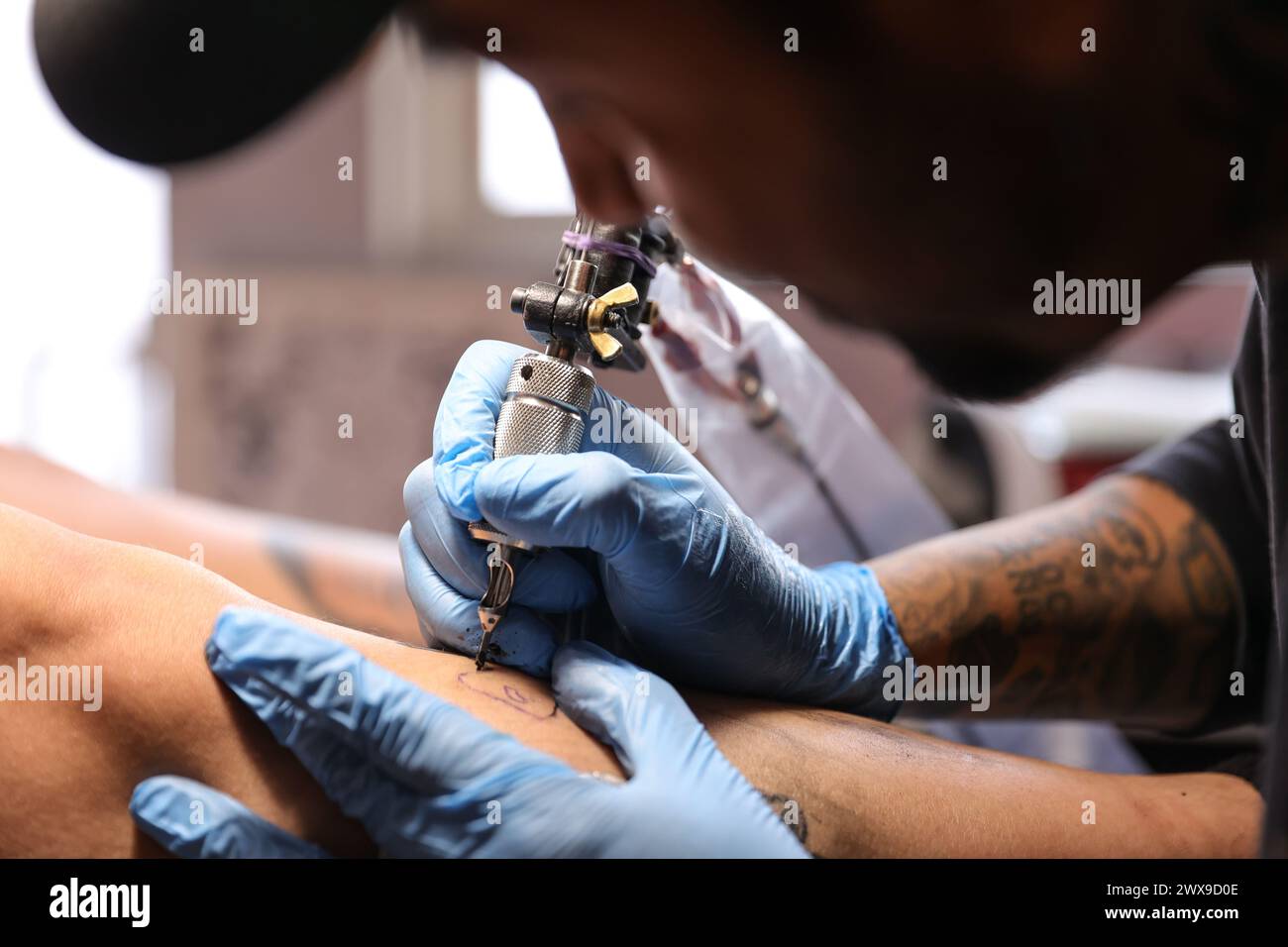 Mexico City, Mexico. 28th Mar, 2024. March 28, 2024, Mexico City, Mexico: Tattoo artist, Israel Ortega known as Mr. Kaliman, tattooing a person's leg at a tattoo salon located in the Iztapalapa neighborhood. With more than 18 years of experience in the art of Tattooing, mixing a traditional American style with Japanese and tribal. on March 28, 2024 in Mexico City, Mexico. (Photo by Luis Marin/ Credit: Eyepix Group/Alamy Live News Stock Photo