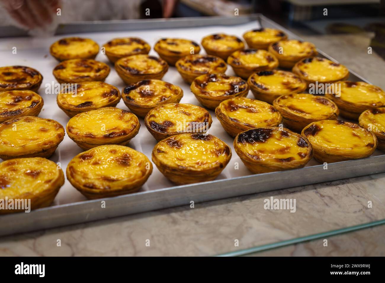 Traditional Portuguese Pastel De Nata pastries on pastry shop counter ...