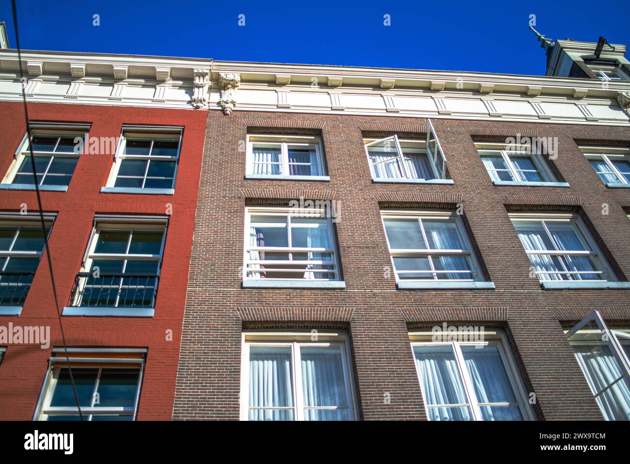 Explore the charm and architectural heritage of Amsterdam through its vibrant streets, where iconic buildings paint a picturesque cityscape. Stock Photo