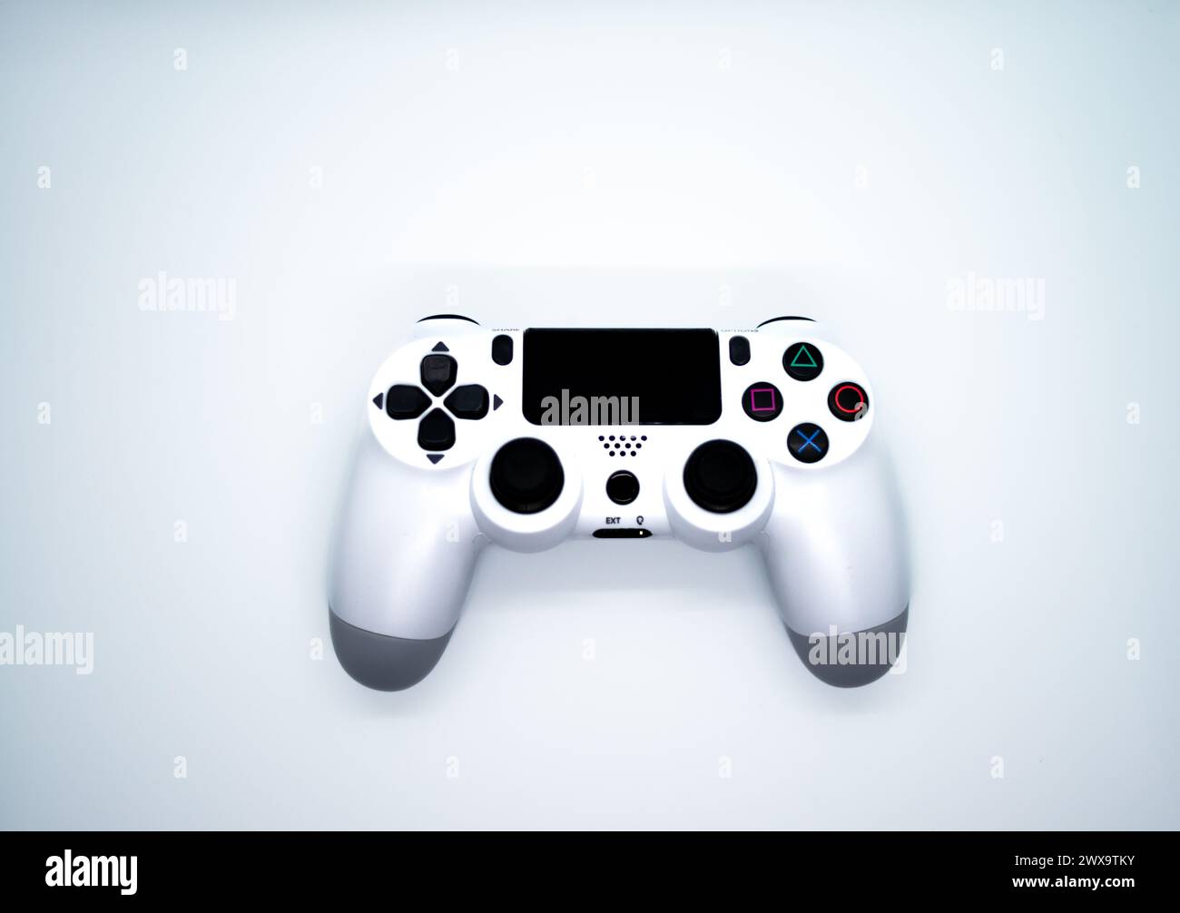 Immerse yourself in the world of gaming with a sleek white gamepad, the ultimate accessory for an exciting digital entertainment experience. Stock Photo