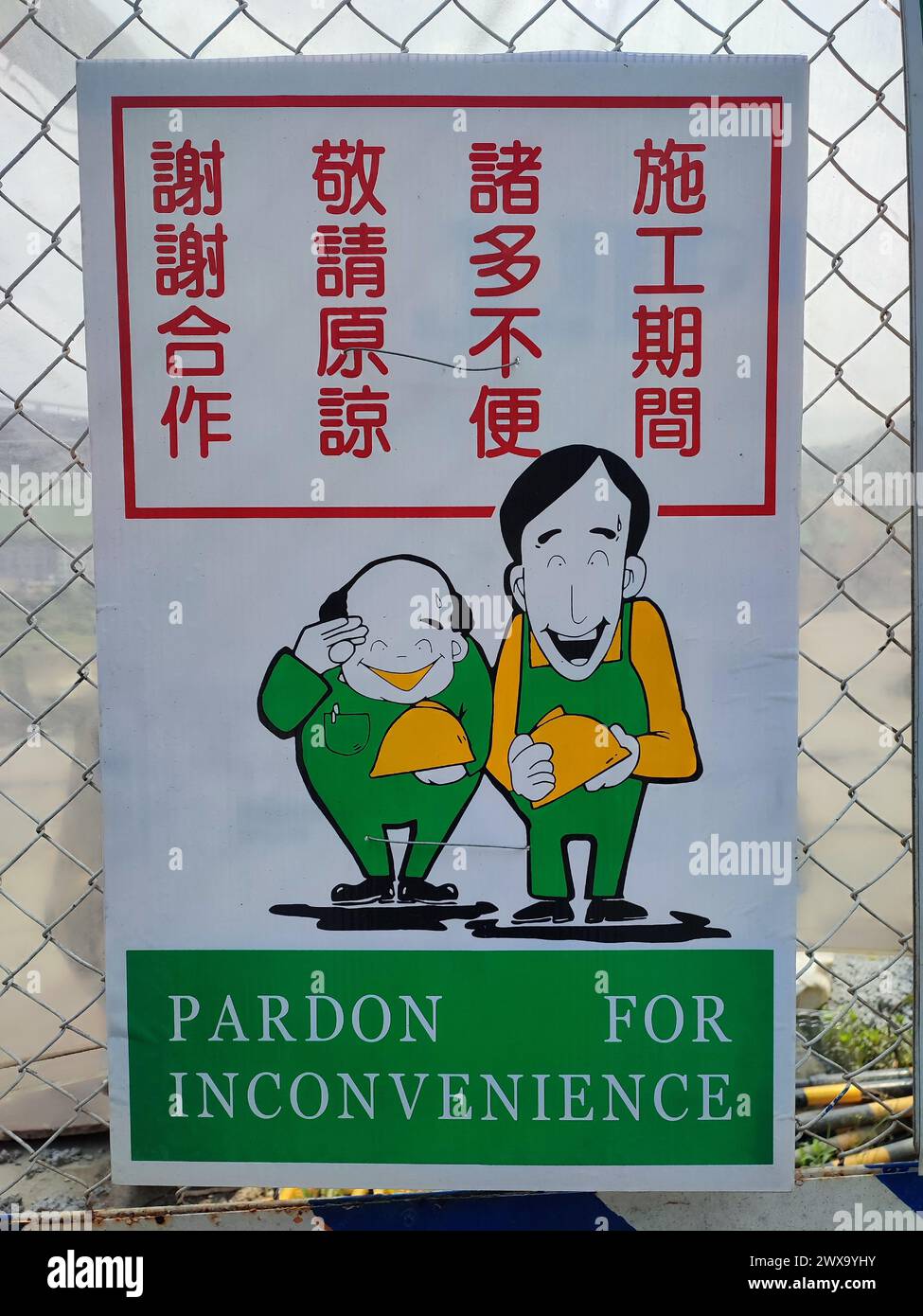 Working sign on job site in English and Chinese Stock Photo Alamy