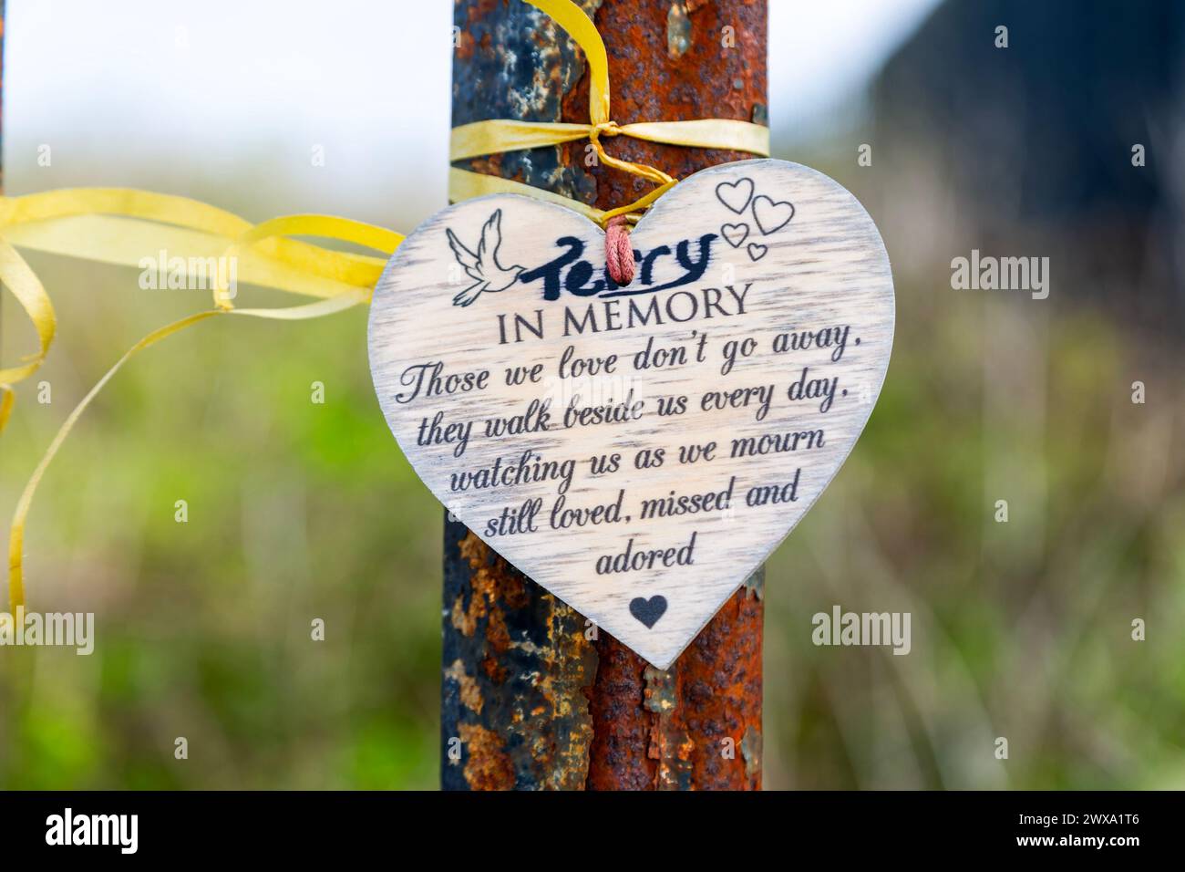 Heart shaped in memory message tied by ribbon to metal post, Felixstowe, Suffolk, England, UK Stock Photo