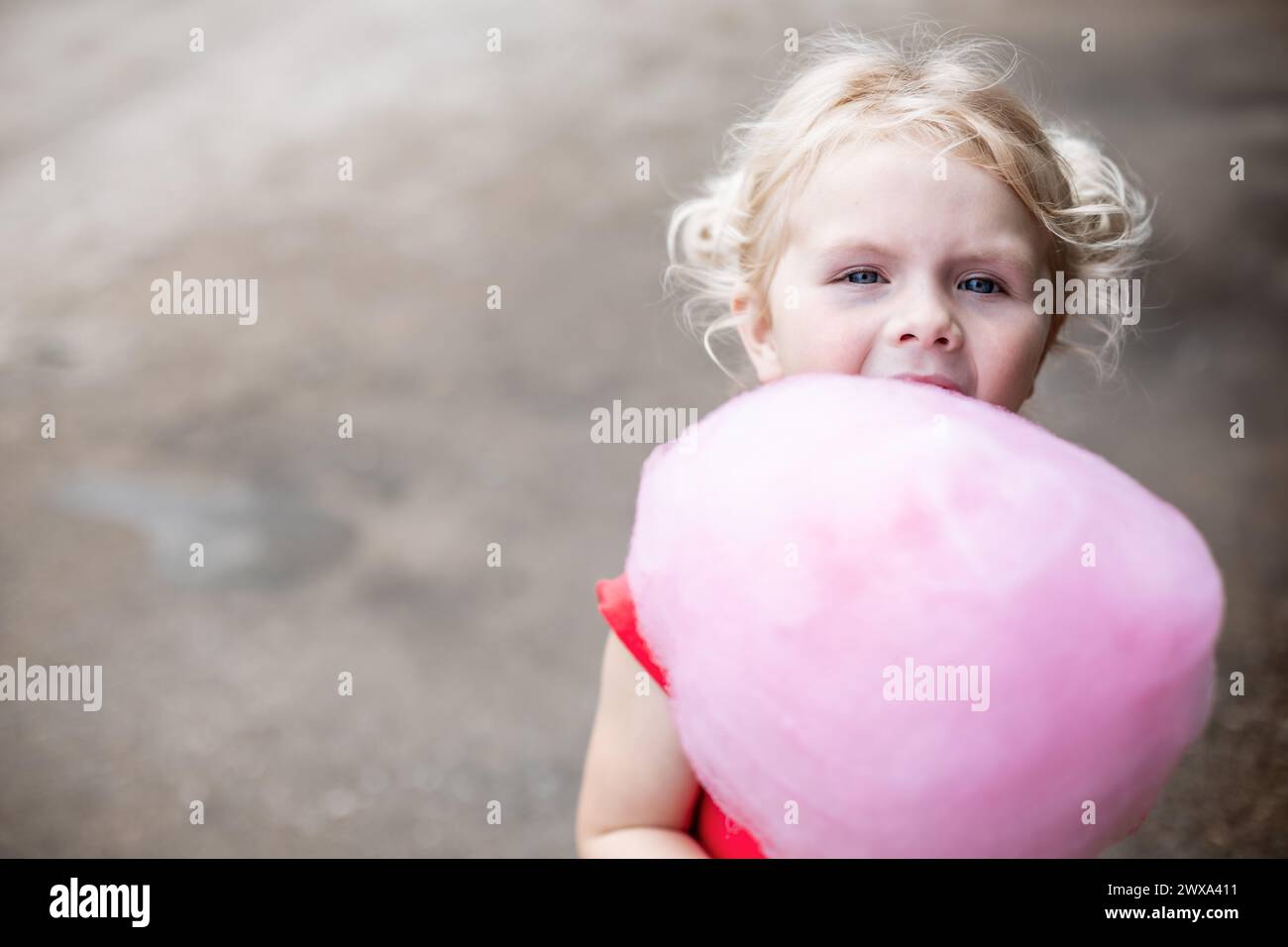 Young girl holding giant pink cotton candy at carnival Stock Photo