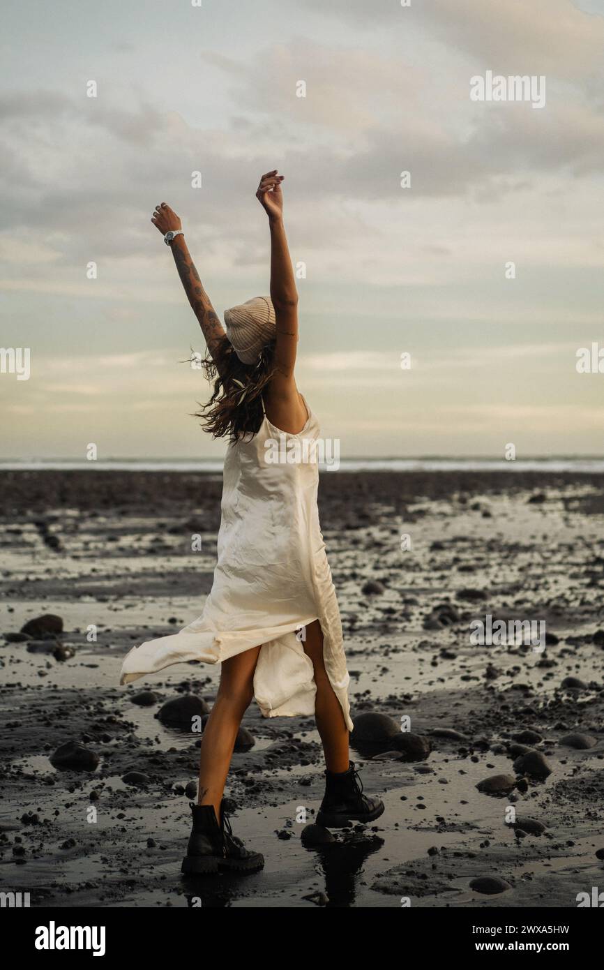 Happy young woman on the beach at sunset, Medewi Stock Photo