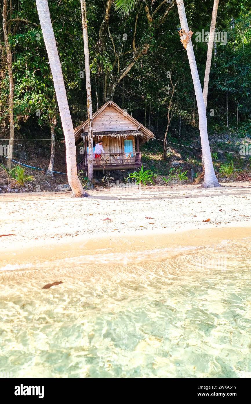 A traditional wooden hut nestled on the sandy shore of a pristine ...