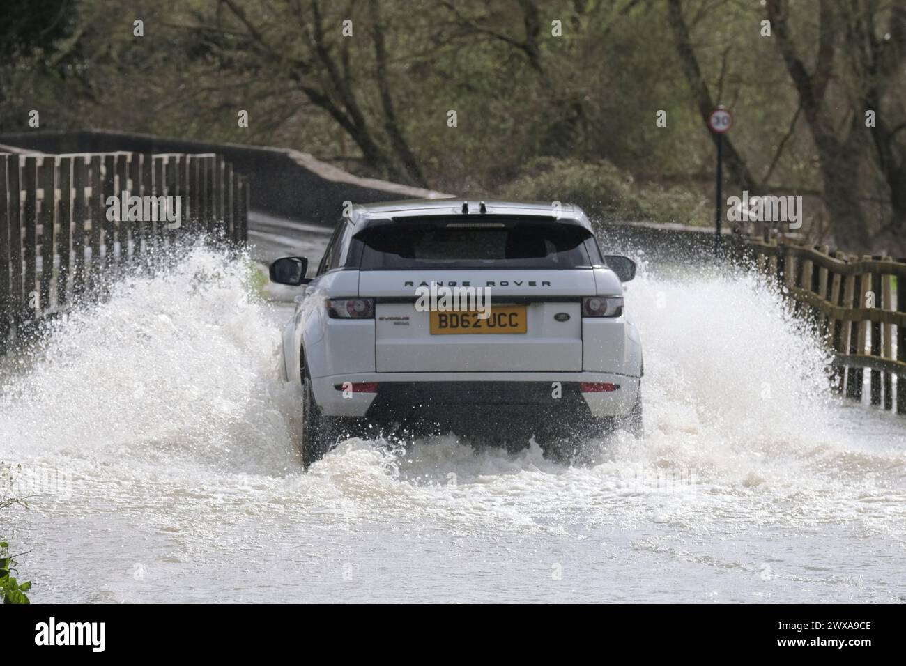 Lacock, Wiltshire, UK. 29th Mar, 2024. The River Avon in Lacock has burst its banks and flooded the road in and out of the village. Advice is not to drive through flood water but the road is passable if you want to make a splash. Credit: JMF News/Alamy Live News Stock Photo