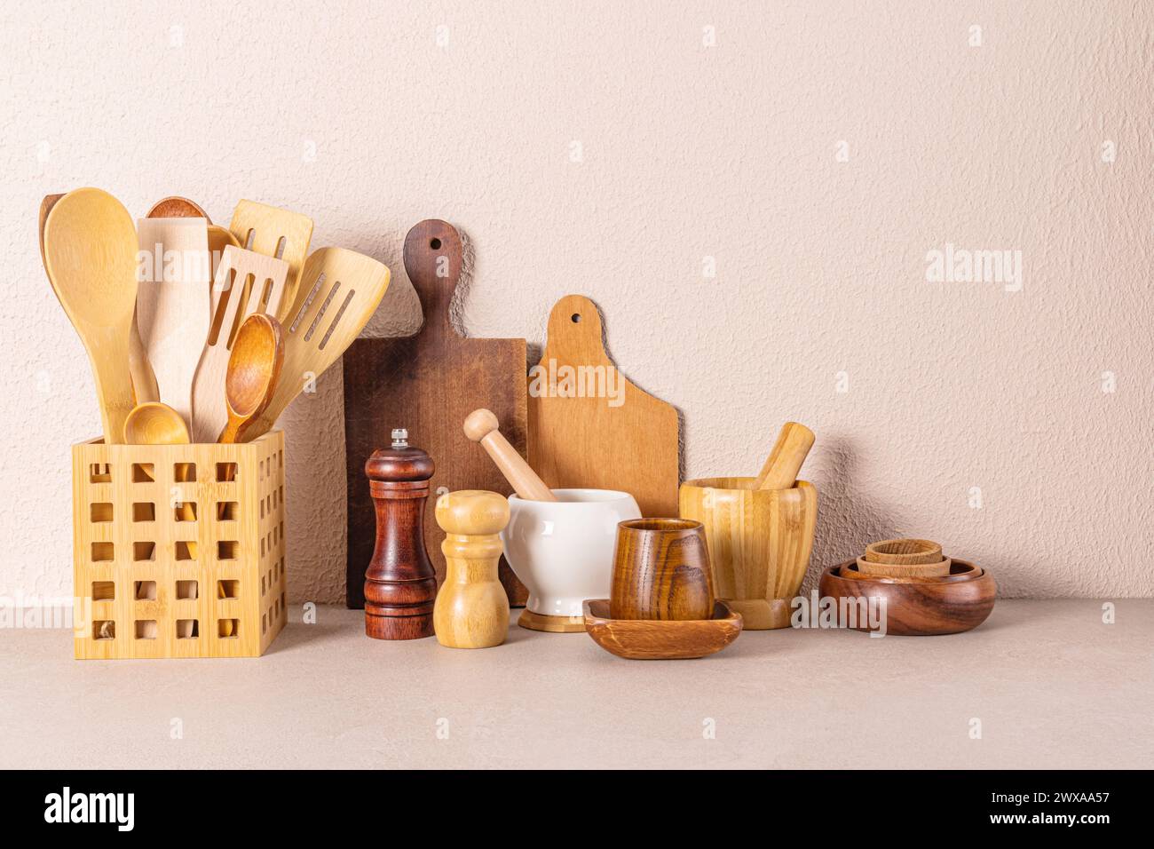 A set of various kitchen wooden utensils on a stone countertop. Eco ...