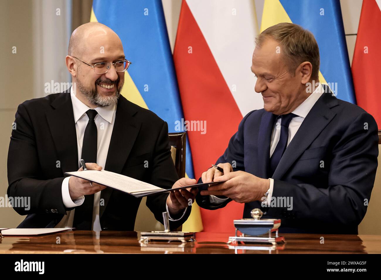Prime Minister of Poland, Donald Tusk (R) and Prime Minister of Ukraine, Denys Shmyhal sign a joint declaration during bilateral meeting between Polish and Ukraine governments in the Polish PM's Chancellery on Ujazdowska Street in Warsaw, the capital of Poland on March, 28, 2024. Stock Photo