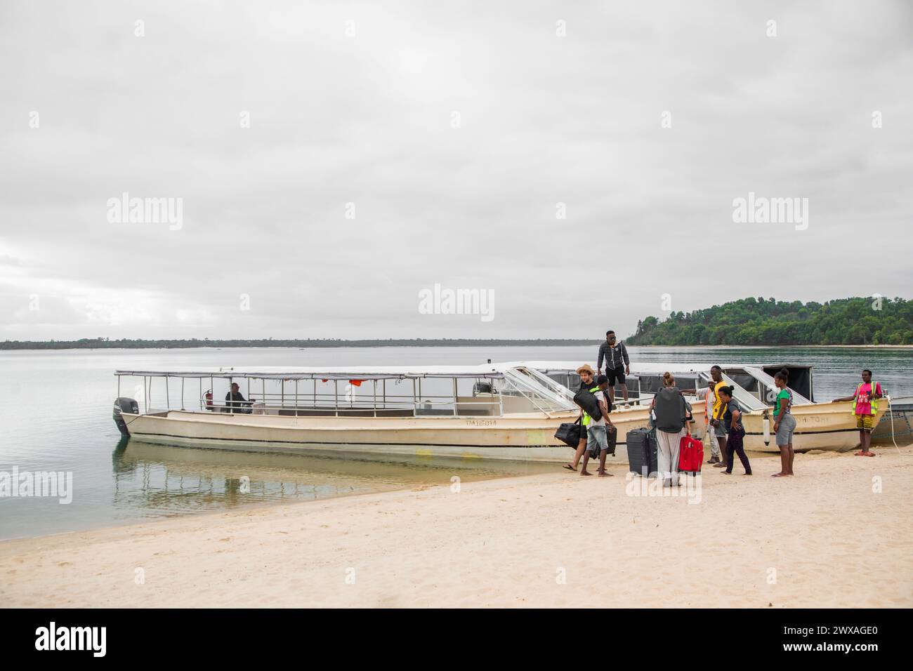 Madagascar,13.10.2023 tourists with luggage disembark on a sandy beach in Madagascar Stock Photo