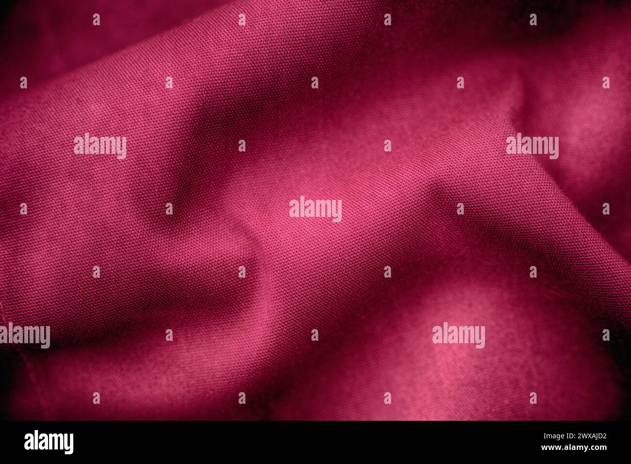 A crumpled magenta fabric texture background. Close up. Stock Photo