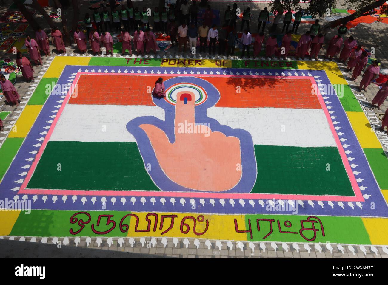 Chennai, India. 29th Mar, 2024. The Power of Thumb during election depicted by a traditional art work of coloured powder, showing Indian flag and a woman's finger marked with indelible ink to raise awareness among people to vote in the upcoming general elections in Chennai, Credit: Seshadri SUKUMAR/Alamy Live News Stock Photo