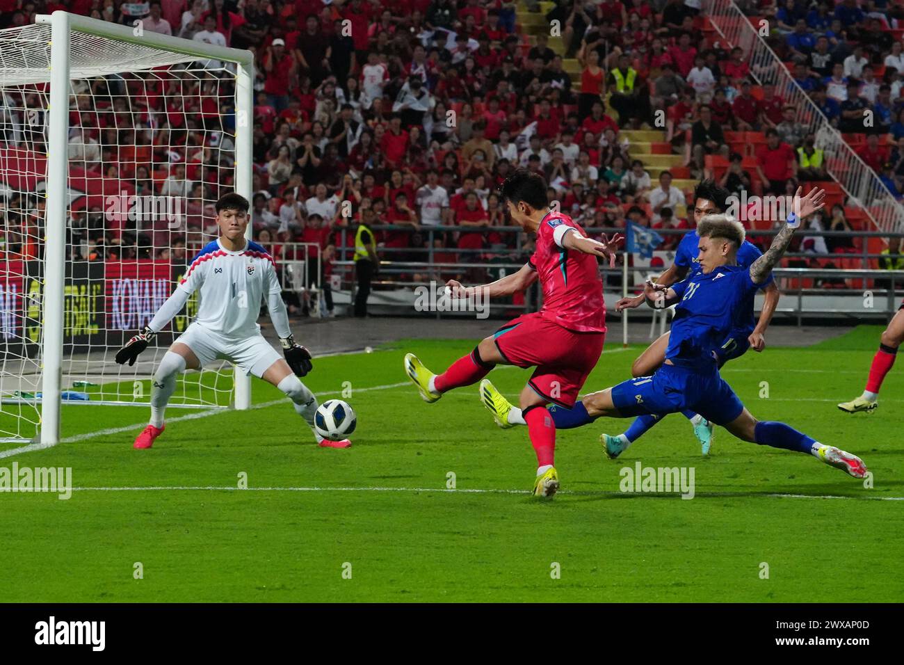 Bangkok, Thailand. 26th Mar, 2024. SON Heung min (red) touches the soccer ball past the goalkeeper of the Thai national team to take the lead, during the FIFA World Cup Qualifying (Group C) match Thailand 0 - 2 Korea Republic at Rajamangala Stadium on March 26th, 2024 in Bangkok, Thailand. (Photo by Teera Noisakran/Pacific Press/Sipa USA) Credit: Sipa USA/Alamy Live News Stock Photo