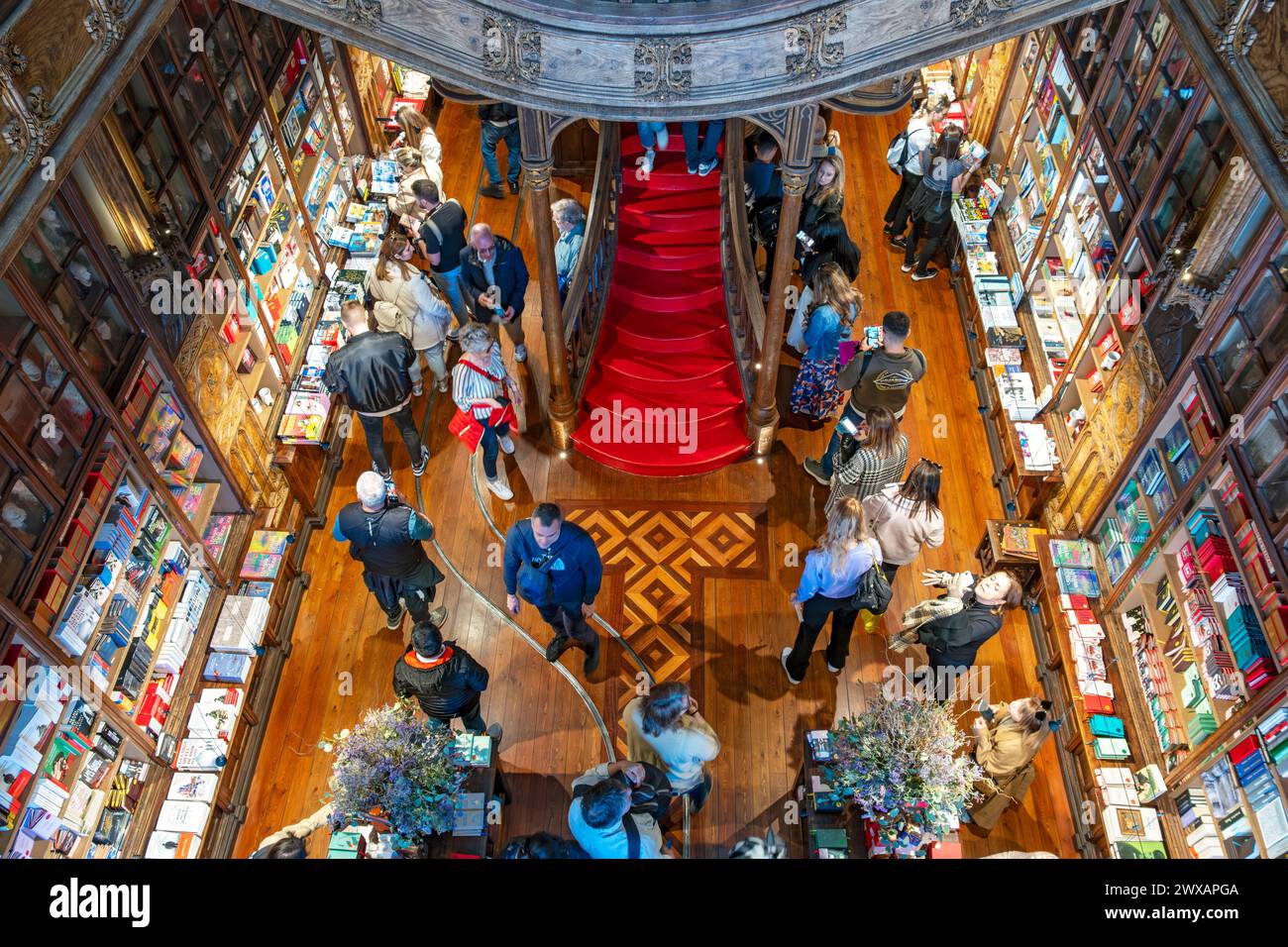 Shoppers browse books  inside Livraria Lello  bookstore in Porto, Portugal Stock Photo