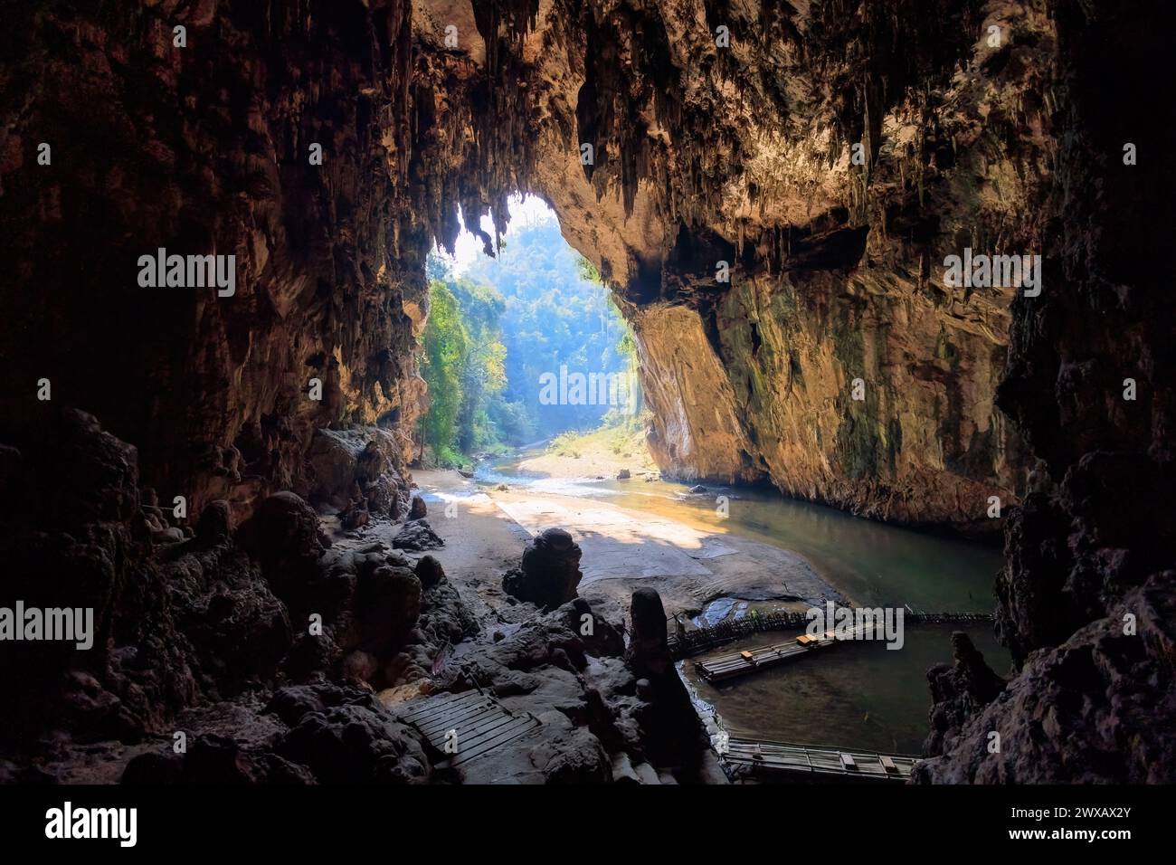 Wide opening in the Nam Tod cave leading to a tropical rainforest. Stock Photo