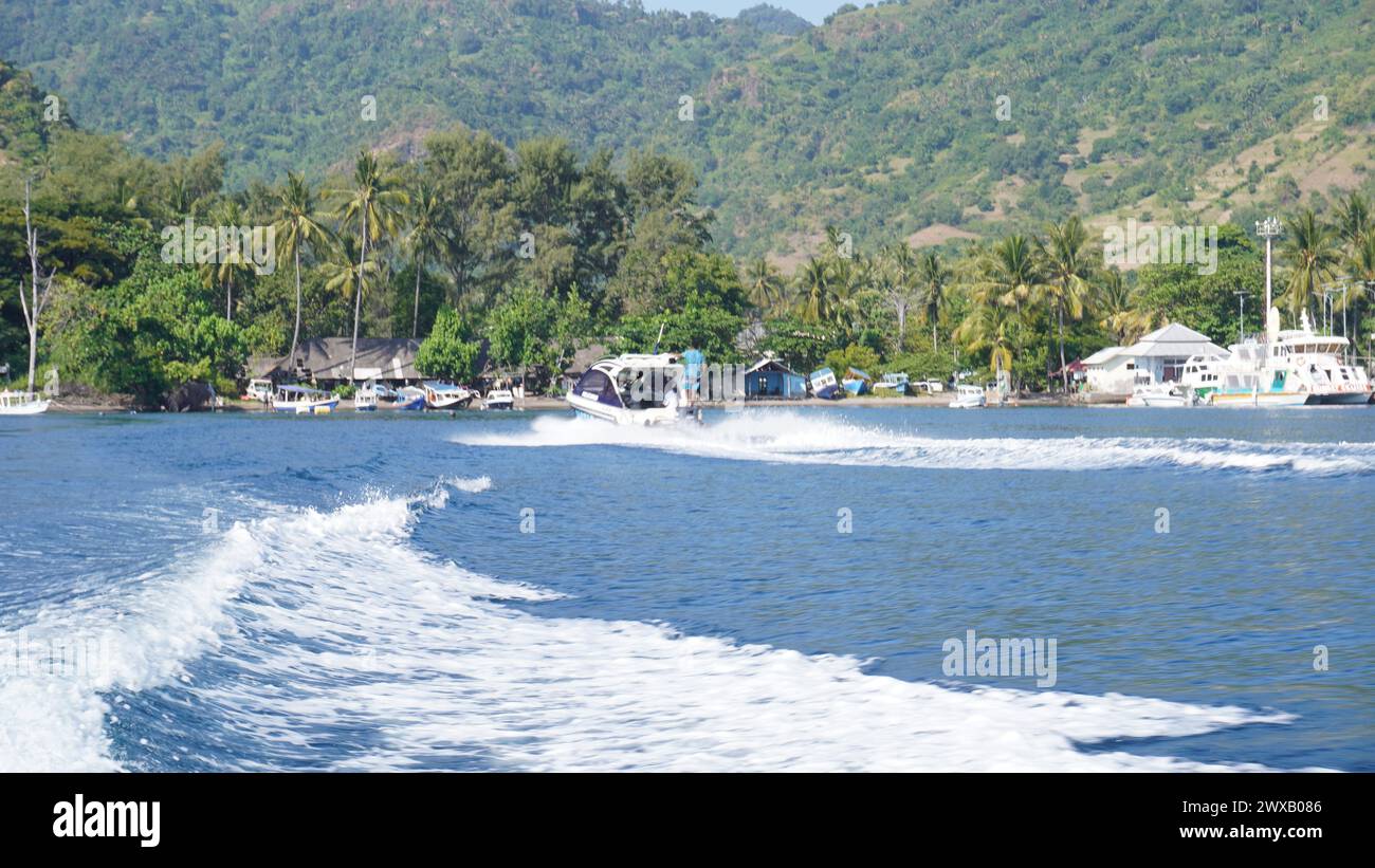 The view from the back of the speedboat when it is crossing to the island of Gili Trawangan Lombok which looks like green hills and sea waves and many Stock Photo