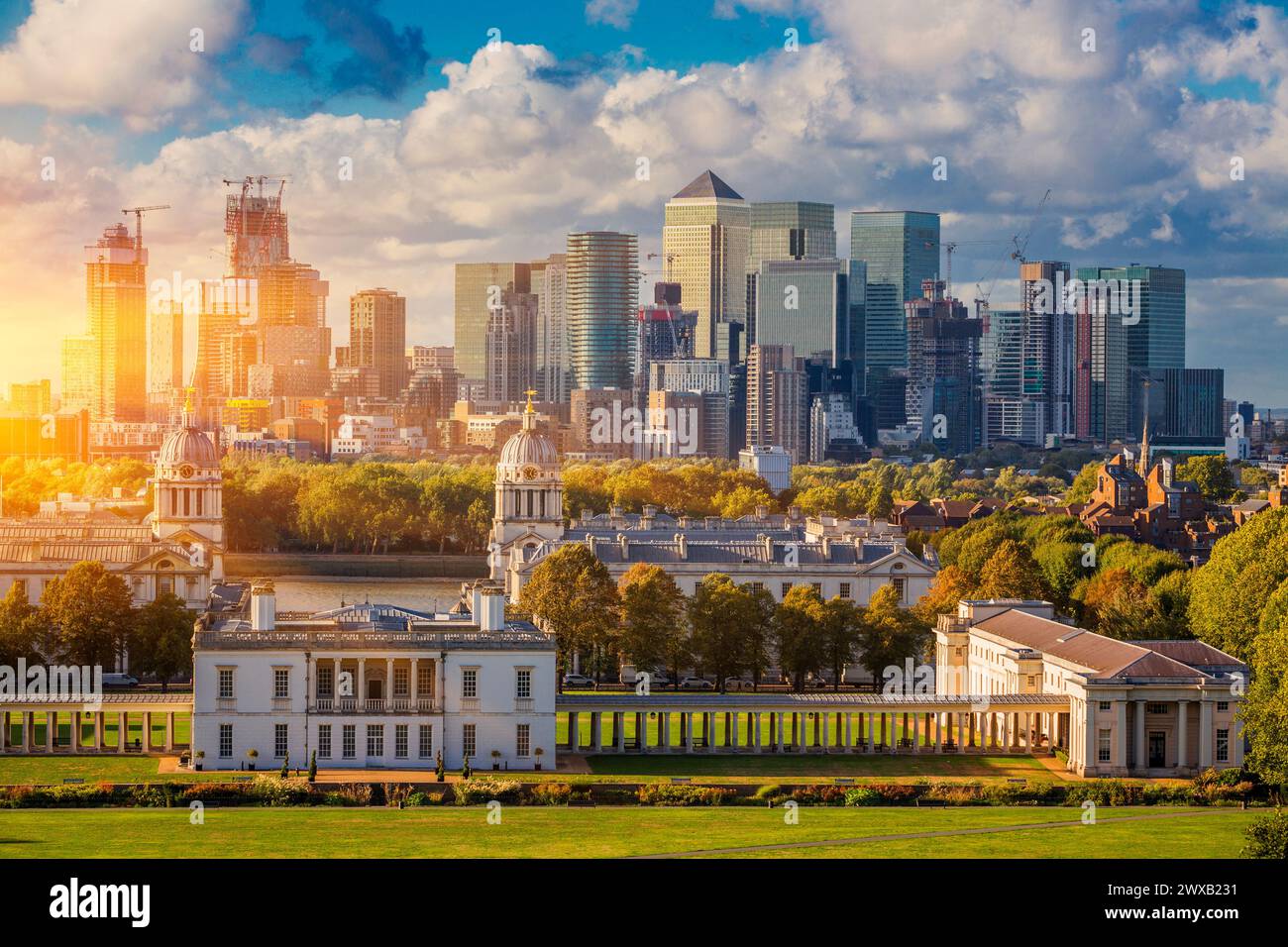 London at Sunset Light, England,  Skyline View Of Greenwich College and Canary Wharf At Golden Hour Sunset With Blue Sky And Clouds Stock Photo