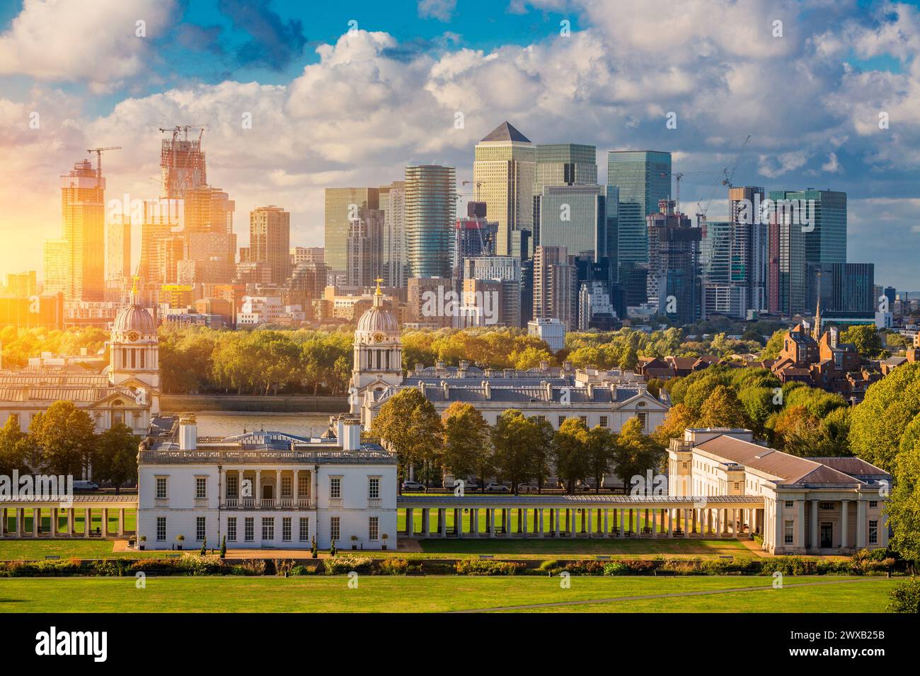 London at Sunset Light, England,  Skyline View Of Greenwich College and Canary Wharf At Golden Hour Sunset With Blue Sky And Clouds Stock Photo