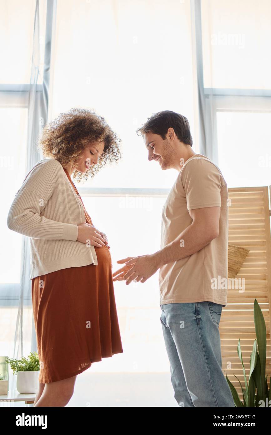 Man Expecting Couple expecting child spending time together at home, man touching ...
