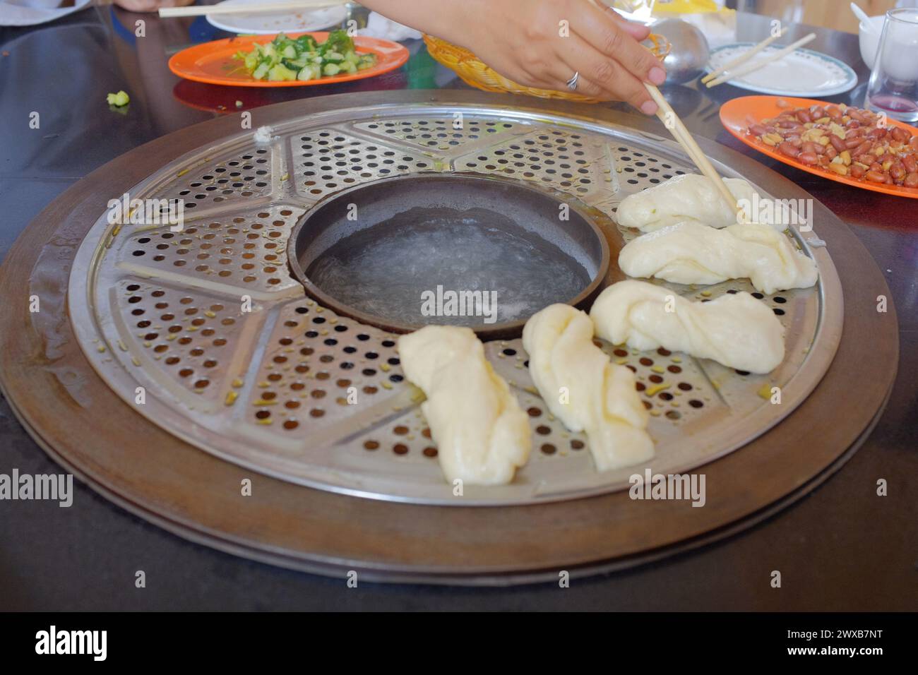 It's a traditional Chinese stove hot pot that is commonly used in the Northeast. The steam from the hot pot is used to cook the bun above. Stock Photo