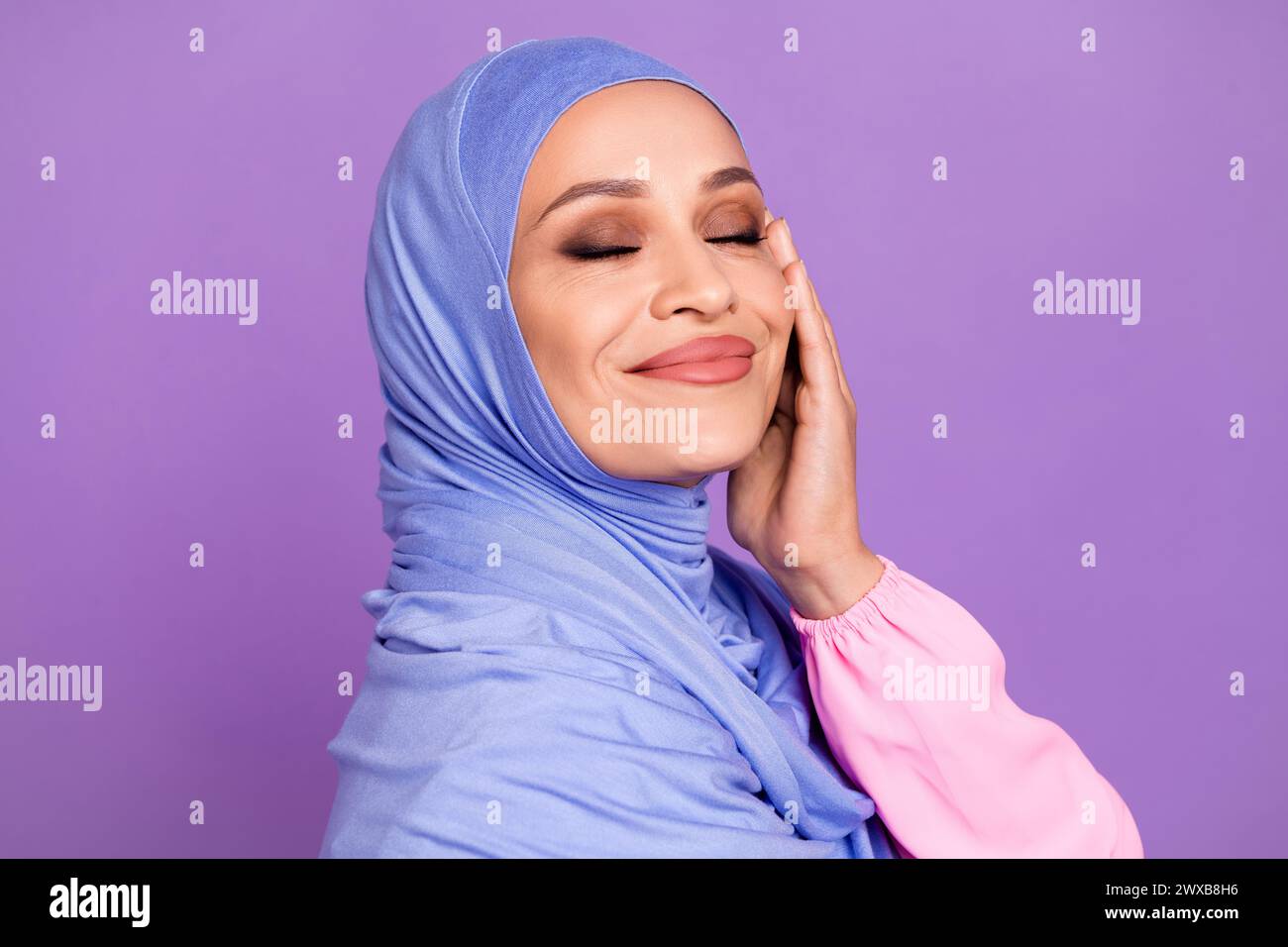 Profile photo of fancy lady apply make up wearing blue arab head wrap