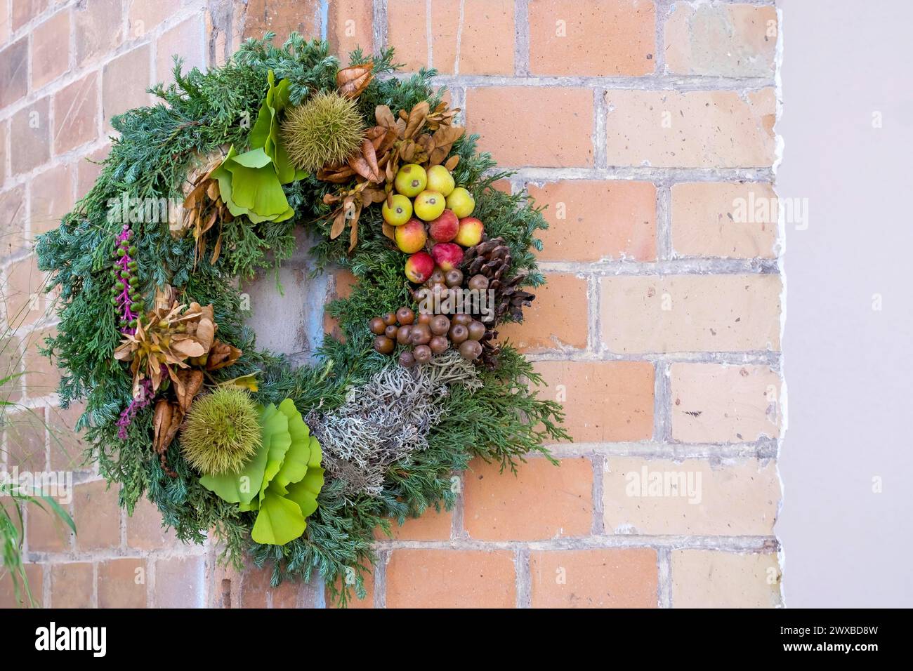 Door wreath made of natural materials in front of a house wall, Rhineland-Palatinate, Germany Stock Photo