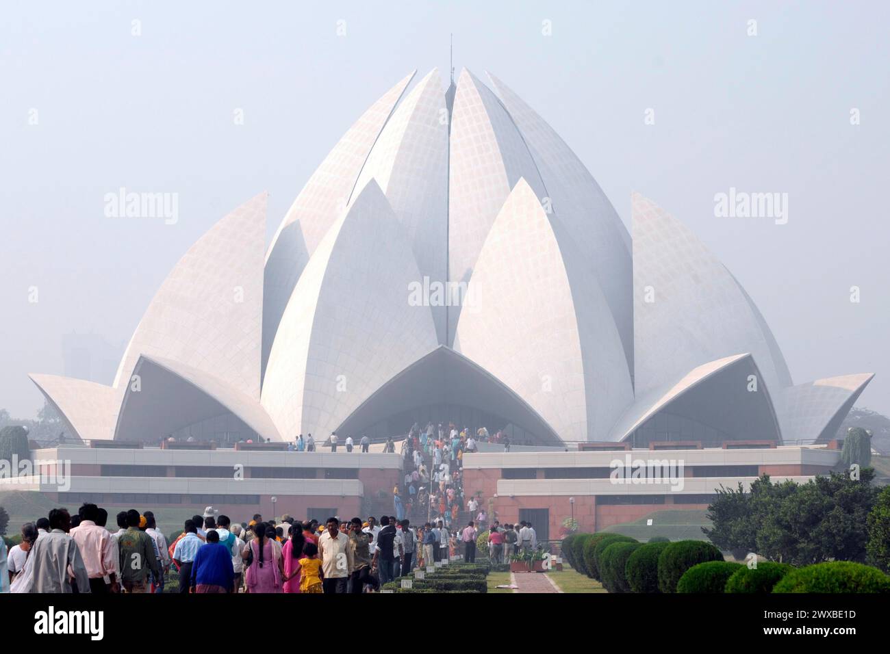 Partial view, Baha'i House of Worship Delhi, North India, A modern building in the shape of a lotus blossom, surrounded by visitors and mist Stock Photo