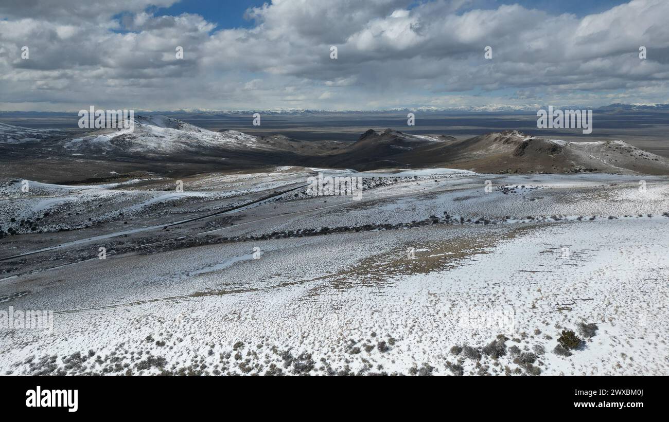 Aerial view of snow-covered mountains under a clear blue sky with ...