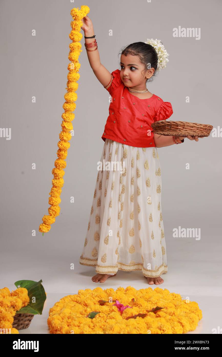 A cute small girl child wearing Kerala dress-golden colour long skirt and  red blouse,onam festival theme, isolated white background Stock Photo -  Alamy