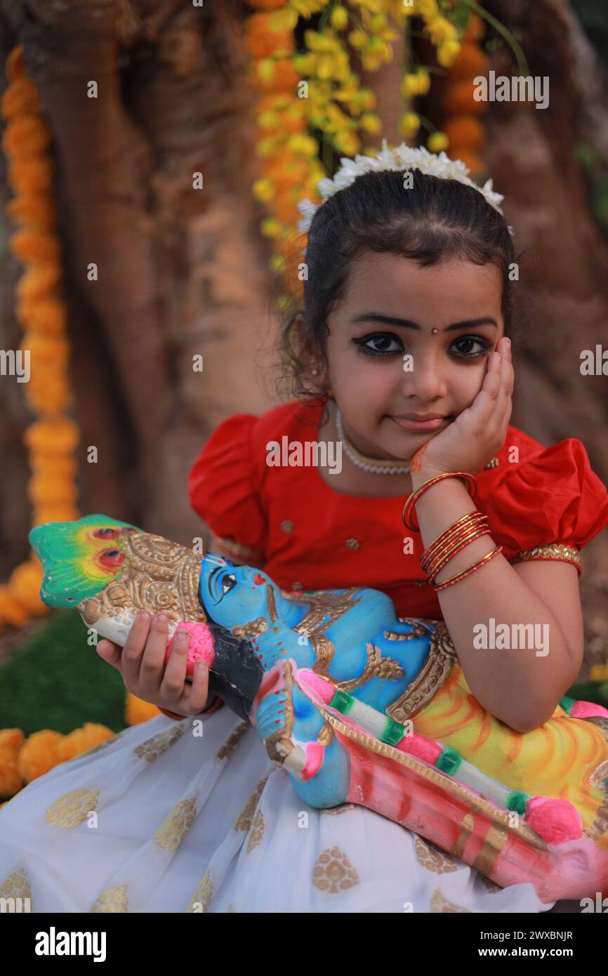 A cute small girl child wearing Kerala dressgolden colour long skirt and red blouse, sitting