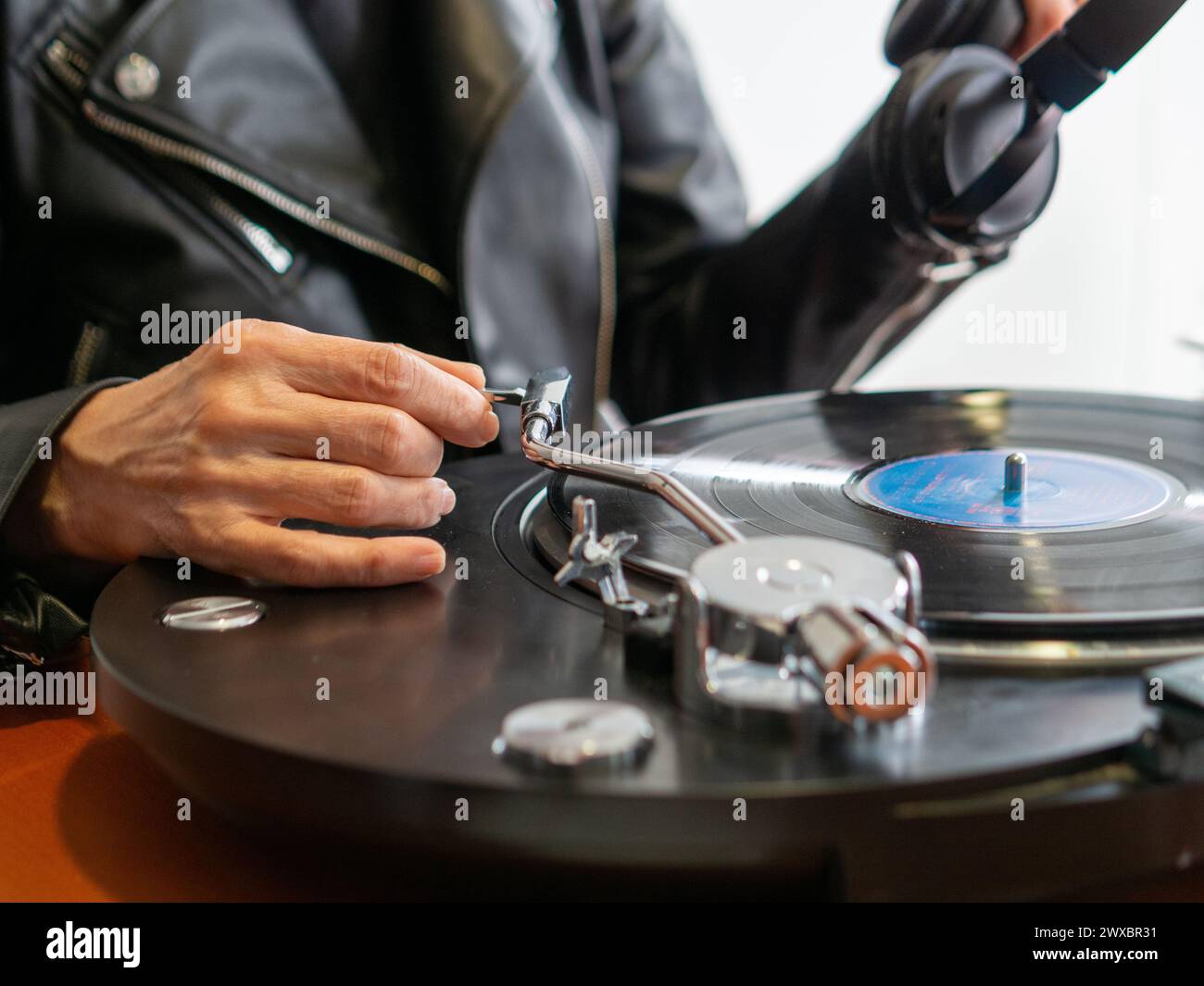 Lady hand holding the tonearm of her turntable ready to play a vinyl record Stock Photo