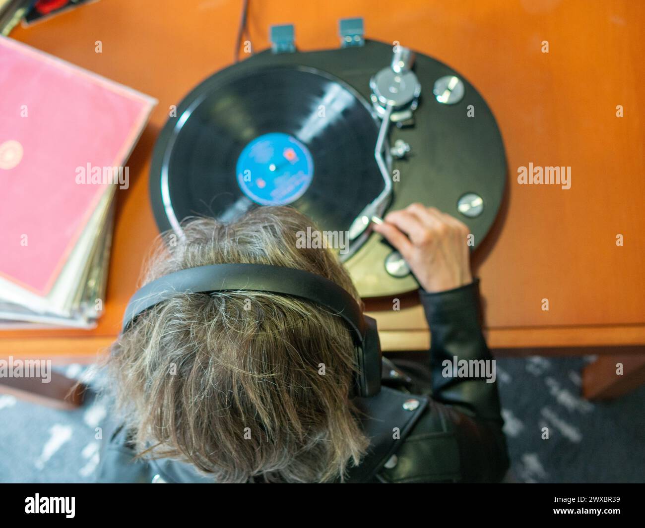 Lady hand holding the tonearm of her turntable ready to play a vinyl record Stock Photo